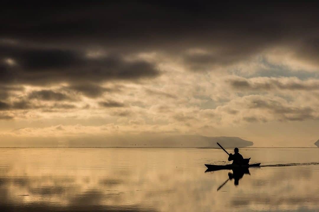 National Geographic Travelさんのインスタグラム写真 - (National Geographic TravelInstagram)「Photo by @CristinaMittermeier | With the day’s light fading off the coast of Greenland, an Inuit hunter returns to shore from the icy Arctic waters. Hunting only occurs in designated areas and this hunter uses a seal skin kayak to avoid frightening prey with a motorized boat. #FollowMe at @CristinaMittermeier for more photos from around the world. #Greenland #ocean #Arctic #CampaignforNature」5月8日 7時12分 - natgeotravel