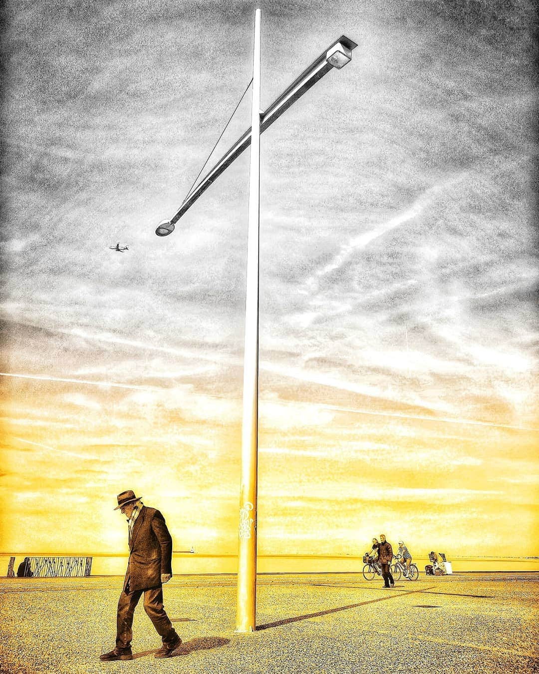 マヌー・ベネットさんのインスタグラム写真 - (マヌー・ベネットInstagram)「Went out early this morning trying to capture iconic images of Thessaloniki using a gold & black & white blend I love the stance of this man, the man in the bg at the gate with the lovers locks the migrant woman setting up her stall a tourist couple biking & a younger man in in the old man's extended shadow cast by the light pole which looks like a crucifix & in the sky above an airplane #thessalonikiphotography #thessaloniki」5月10日 1時35分 - manubennett