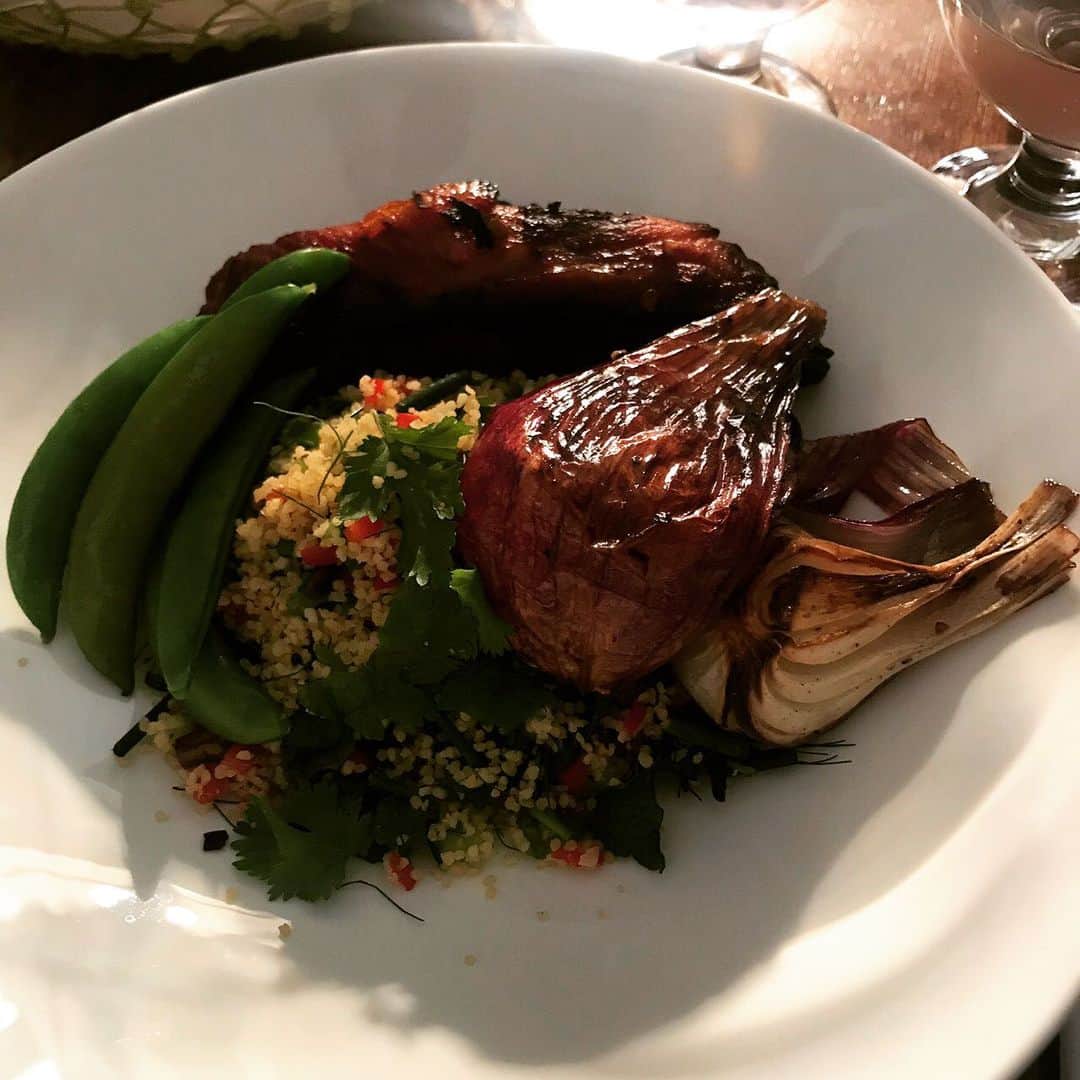 のインスタグラム：「妻が月イチの料理教室で作ったスモーキースペアリブの写真を送ってきた。飯テロだ！  クスクスの山に焼き玉ねぎなどとともに盛り付けられていて、なかなかカッコいい。数日後に食べさせてくれるものと信じたいです。」