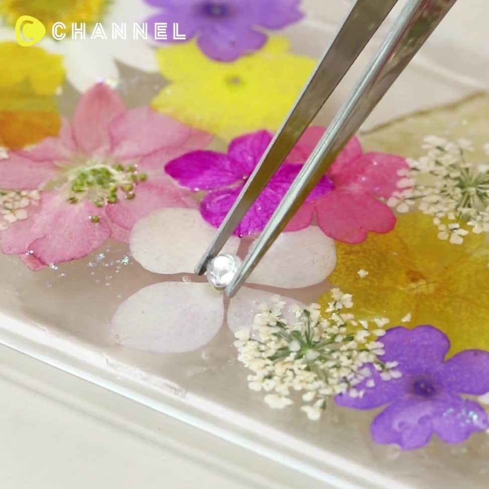 C CHANNEL-Art&Studyのインスタグラム：「💐DIY: Pressed flower clear phone case💐 💐本物のお花で作るから世界にひとつだけ♡まるでお花畑な｢押し花スマホケース｣💐 . 💗Check👉 @cchannel_girls 🎶 💗Follow me👉 @cchannel_artandstudy 🎵 📲C CHANNELのアプリもよろしくお願いします💕 . 【📱MATERIALS】 ・Transparent phone caes ・Pressed flowers ・UV Resin ・Glitter powder ・Stones ・Pen with flat head ・Tweezer set ・Toothpicks . 【📱STEPS】 1. Paint UV resin liquid on a phone case  2. Use a tweezer to transfer pressed flowers onto the case then make a preferred pattern.  3. Apply UV light to dry  4. Paint another layer of UV resin on the case  5. Sprinkle glitter powder on the case  6. Stick decorative stones on the case  7. Apply UV light again to dry to finish . . 可愛い色とりどりのお花で埋め尽くされたスマホケースは華やかで大注目されています♡ . そんな大人気の押し花スマホケース、実はとっても簡単に作れてしまうんです♪ . 本物のお花で作られた押し花でつくるから、誰とも被らない世界にひとつだけのオリジナルスマホケースができますよ！ . 【📱用意するもの】 ・スマホケース ・押し花 ・UVレジン ・ラメパウダー ・ストーン ・平筆 ・ピンセット ・爪楊枝 . 【📱作り方】 ①スマホケースに筆でUVレジンを塗り広げる  ②ピンセットで押し花を好みの形に並べる  ③1度硬化させる  ④再びUVレジンを筆で塗る  ⑤ラメパウダーをふりかける  ⑥ストーンをのせる ⑦再び硬化させる 完成！ . 強度を高めたい方は最後にもう一度UVレジンを塗り硬化させることをおすすめします♪ . 企画・制作：永田　紗也 . . #smartphonecase#casesmartphone#smartphonecases#iphonecases#flowercase#pressedflower#casebunga#caseiphonemurah#casemurah#pressedflowercase#handmadecase#kawaiifashion#resinflowers#craftsfeed#resincase#resincraft#customcase#floral_lover#flowerstagram#resincrafting#uvresin#kawaiistyle#handmadewithlove#iphoneaccessories#decodencase#kawaii#caseforiphone#handmadegifts#loveresin」