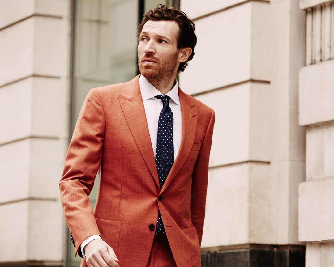 ギーブス&ホークスのインスタグラム：「Get your perfect fit in #GievesandHawkes. Book your made to measure experience now via the link in the description.  Model wears Burnt Orange Plain Weave summer suit, with fabric from Holland And Sherry’s ‘Cool Breeze collection.’ #GievesandHawkes #mtm #suting #tailoring」