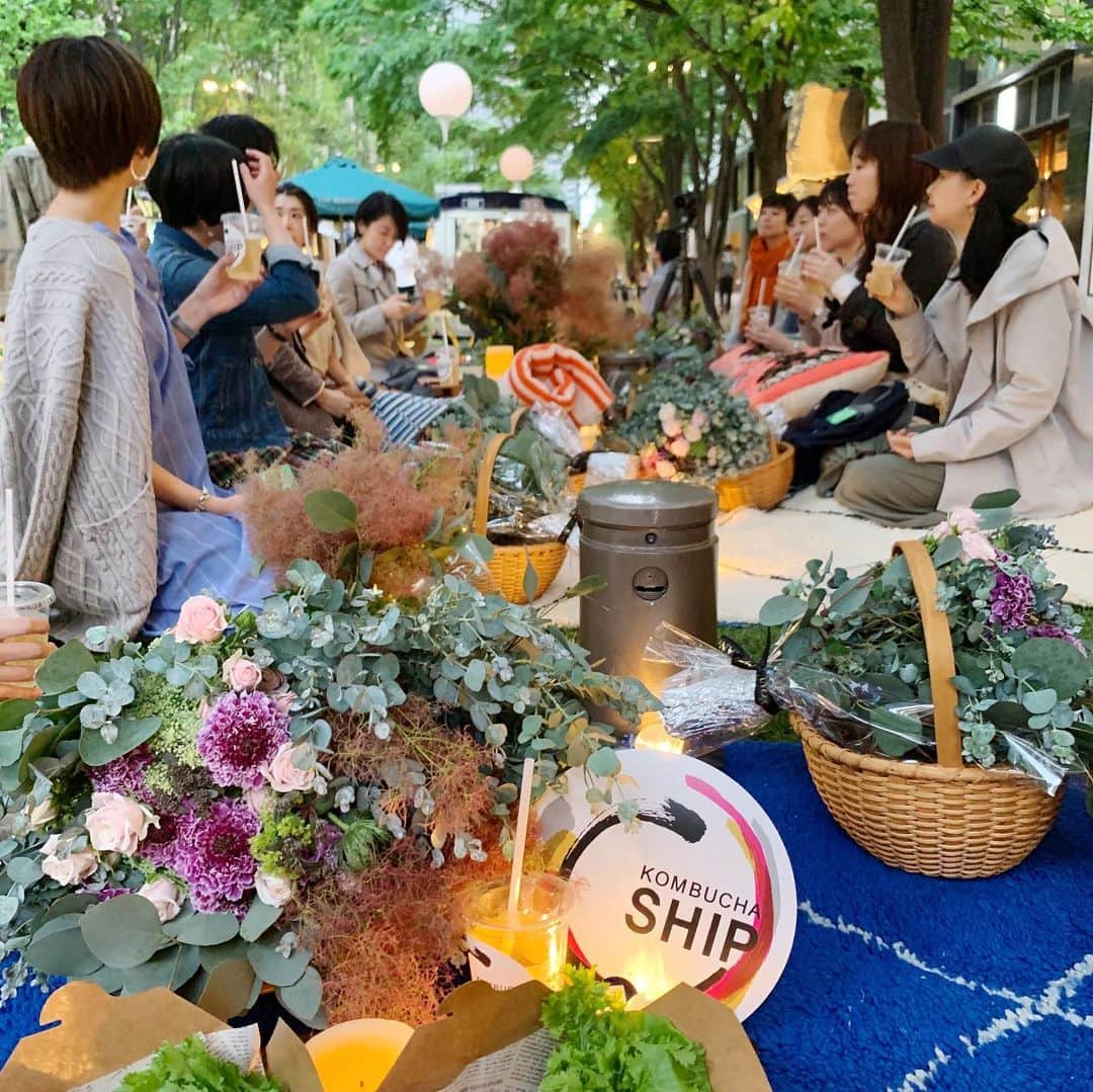 高山都さんのインスタグラム写真 - (高山都Instagram)「昨夜は、丸の内仲通りで初めてのトワイライトピクニックでした。 参加者の皆さんには、それぞれバスケットに @ganonfloristgallery による大きなブーケと @yukiya.terai による #幸也飯 を詰めてご用意。 ドリンクはワタシも最近ハマって飲んでいる #コンブチャ @kombuchaship  モロッコのラグを敷いて、ぐっと距離の近い特別だけど身近な時間。 はじめましても、2時間色んな話をすれば、みんなニコニコ。 どんな雰囲気の場所にして、どんな花にしたいかとか、フードはどんな風にしたいとか、企画から携わっていたので、イメージ以上に仕上がって、スタッフ皆さんに感謝です。 普段のイベントでも、なかなかこんな濃縮な時間はないので、とても楽しかったです。 みんなで恋の話したり、生き方の話をしたり。 これからは、もっとコトを共有できる企画を考えていきたいなぁー。 この天然芝のパーク仕様は18日まで。 気持ちのいい季節だから、昼も夜も都会のお散歩コースにぜひ。 実は #ゆーたーぶーみー も揃っていて、なかなかレアな時間でしたw みんなが、こんなこと計画してほしいってどんなこと？ よかったら、教えてください！！ #marunouchistreet #高山都 #幸也飯 #kombuchaship」5月15日 16時47分 - miyare38