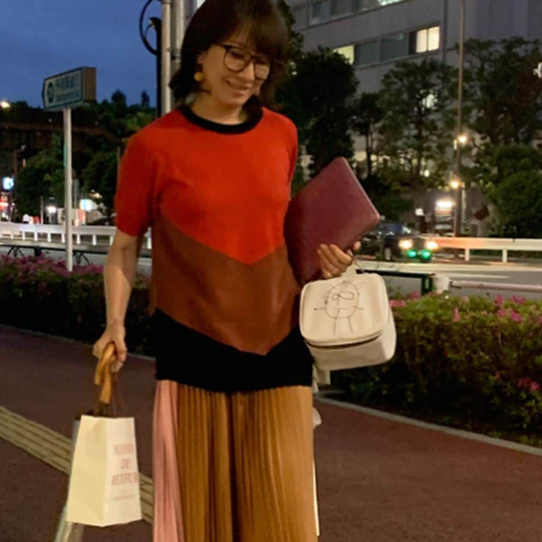 風間ゆみえのインスタグラム：「＊ブロックカラーの赤いニット、キャメル、ピンク、ホワイトの3配色になっているプリーツスカート、PVC素材のバニティバッグすべて @plan_c_official ＊大ぶりな淡いピンク色の天然石と、キャンディイエローの天然石で、左右デザインの異なるアシンメトリーなピアス @la_boutique_fantasque ＊サンダル @marni ＊型押しのピンク色の手帳 @smythson ＊眼鏡 @zoff_eyewear  #yumie_k_style」