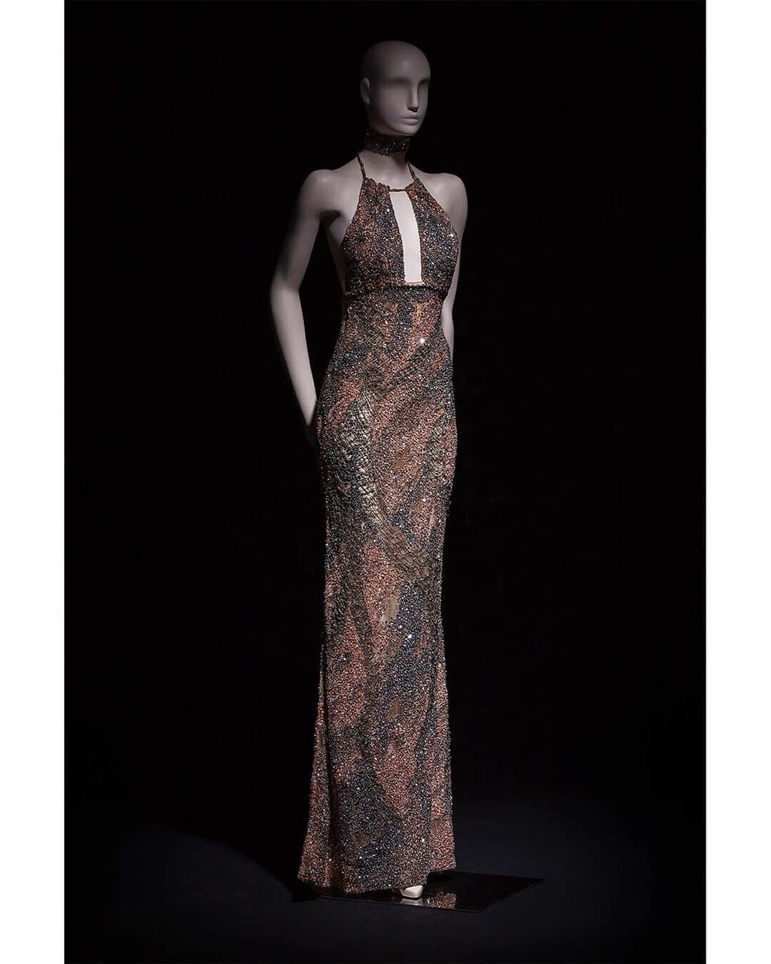 のインスタグラム：「Nzinga - Long sleeveless column gown embellished with crystal embroideries and precious nude, gold and pink sequins skilfully inlaid with metal chains and macrame from the new "Divina Africa" #RobertoCavalliCouture collection exclusively available at our Cannes Boutique.」