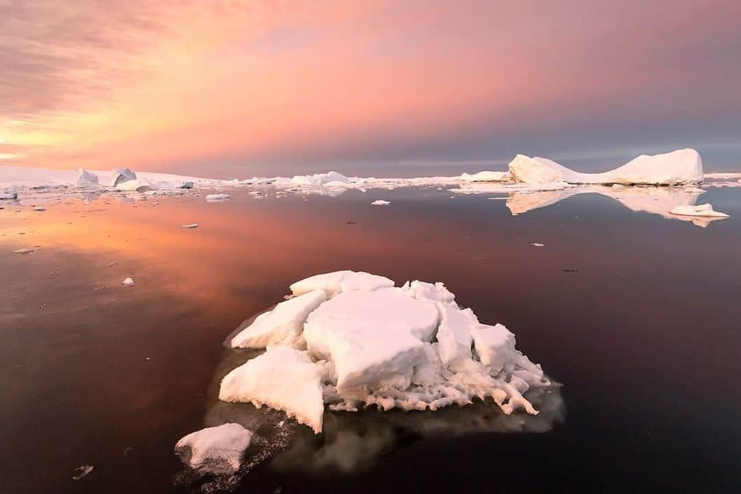 National Geographic Travelさんのインスタグラム写真 - (National Geographic TravelInstagram)「Photo by @daisygilardini | A strong foreground is essential to any successful landscape photography. We look at things three-dimensionally with our own eyes in real life, but what we see through photography is flattened into a two-dimensional image. In order to enhance depth perception and lend an illusion of a three-dimensional space, one needs a strong foreground to lead the viewer’s eye into the image. In this particular instance, I chose to use the iceberg in the foreground. I took extra advantage of the iceberg’s complementary colours, in order to lead the eye into the beautiful sunrise reflection and ice field in the background. #Antarctica #iceberg #sunrise #landscapephotography #polar #conservation #climatechange #climatechangeisreal」5月18日 22時04分 - natgeotravel