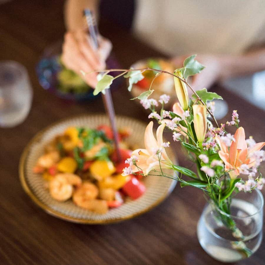 甲斐麻美さんのインスタグラム写真 - (甲斐麻美Instagram)「キッチンカウンターで 作りたての "あつあつ" ご飯を食べる そういえば 憧れだったかもしれない  夢のマイホーム なんてことも 昔のわたしは夢見ていた 「〇水ハウスの3階建てに住みたい」  と、子供のわたしは じいちゃんばあちゃん 父母姉弟 みんなで暮らす 立派な家に憧れていた  憧れて 「いた」 そう、もはや 過去形なのだ  今は 古い一軒家を購入し 夫婦であらゆる箇所を蘇らせている 「本当にこの家を買うの？」 そう心配する人は ごく僅かで わたしたちが 熊本で散々リノベーション慣れしてる事を知ってる友達たちは やはり 背中を押してくれたのだった  床下から壁抜き トイレの移設までも やっていて 今は 洗面脱衣所を作っているし そのうち お風呂も新しく変える  全部 わたしたち  いや、主にhato(夫)が一人でやっている  古い家を新しく ではなく 自分たちの好きなように蘇らせることは なんて素晴らしいのか  ピカピカな新築も もちろん素敵だけど リノベーションは蘇る過程までもが愛おしくて たまらない 毎度 凄い事をやってのけていると 自画自賛してしまうのだ (主にhatoが一人でやっているのだぞ、わたし)  そんなわけで 自分達で一から作ったキッチンで わたしは 料理をし ご飯を食べて こんなにも贅沢な気持ちで 満たされている  猫たちは 窓を開ければ やってきて 窓の外には 何もいない  わたしには見えないし  感じないのに 猫たちには 何か見えているのかもしれない  じっ と息を潜めて ふたり その 「何か」 を見ている  キッチンに お花を飾りたいな  と 珍しく思ったのは 五月の風のおかげだろう  この季節は 色々な草花、木々たちが元気で 風に乗って その溢れた元気を運んでくれるようだ  そんなタイミングで 毎週もしくは隔週でお花が届く定期便 #medelu さんのモニターに選んで頂きました  モニターって なんだか"こそばゆい"感じがする でも ポストにお花が届くって どんな感じなんだろう？と 素直に興味が湧き 受けさせていただきました  明治から100年以上(！)続く会社のスタッフさんが手掛けているサービスらしく お花の品質と鮮度を大事にされています  すごい事だなと 時代の変化 進化に驚いた次第であります 明治、大正、昭和、平成、令和…スゴ…  届いたお花は とーーーっても可愛かった わたしの中の 女子力も上がってくれたわけです  ご飯食べながら お皿洗いながら目線の先に お花があるわけよ  我が家の興味津々ニンジャ猫もしっかりお花見してました (※舐めたりしないように注意しています)  ありがとうございました  気になった方はこちらへどうぞ↓ @medelu_official  #パプリカ #sweetpepper #パプリカとわたし #〇〇とわたし #medelu #me #vegitable #delistagram #delistagrammer #food #foodstagram #フードスタグラム #art #野菜 #homemade #myhome  #リノベーション #ときめき #sparkjoy #DIY #photooftheday #花のある暮らし #mykitchen #photoshooting #husbandphotographer #嫁グラフィー #元保護猫 #ねことわたし #甲斐麻美」5月19日 13時16分 - kaico_asami