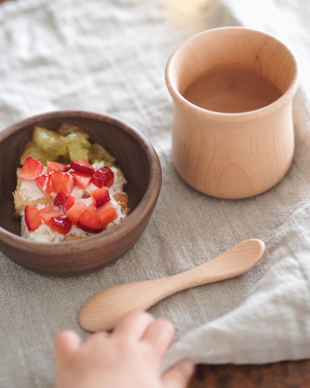 のインスタグラム：「Snack time♡ . . . ちいさなおててがおやつに伸びる🙌🍓 . いちごのオープンサンドのクリームは 水切りヨーグルトで🐄 . これまで愛用していた器にヒビが入って 新しいのを探してたときに @cunaselect で見つけた スナオラボの木のうつわ🥣♡ . スプーンもカップもMiaが自分で持つのに ぴったりのサイズ感で使いやすそう🥰 . 器は小さく見えるのにごはんやリゾットを入れるとその容量にびっくり❣️ お皿の縁の返りでスプーンですくいやすいとあって我が家でさっそく大活躍✨ . カップにお皿を重ねると可愛いキノコになるんだけど こちらはまた今度ストーリーで🍄 . . . #ベビーの器 #きのこのうつわ #メイドインジャパン #madeinjapan #cunaselect #cunaselectlife #生後15ヶ月 #1歳3ヶ月 #1an #クーナセレクト #クーナセレクトライフ #miababyliving」