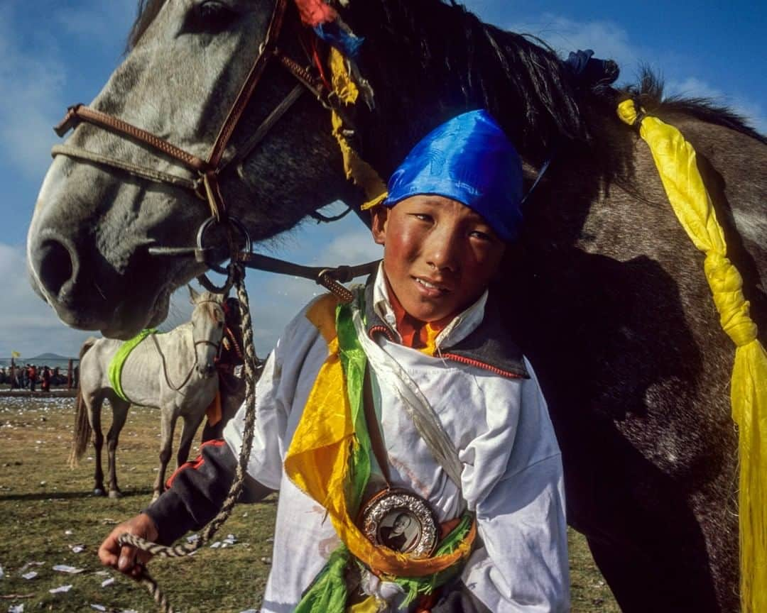 ナショナルジオグラフィックさんのインスタグラム写真 - (ナショナルジオグラフィックInstagram)「Photo by Fritz Hoffmann @fritzphotos | A first-time jockey, 14-year-old Sonam Dargye nervously waits to be called to the 2000-meter speed race with horse Gyumei at the Maqu Gesar annual horse races in the Gannan Tibetan prefecture in Gansu, China. Sonam Dargye wears a picture of Gongthang Tsang, the living Buddha of the Labrang Monastery, on his chest. The Tibetan horse racing season is approaching. This week I'm posting pictures from races past, longing to be there myself. Please check out my feed at @fritzphotos #FritzHoffmann #MaquHorseRaces #MaquGrasslands #TibetanHorseFestival #Gannan」5月20日 6時34分 - natgeo