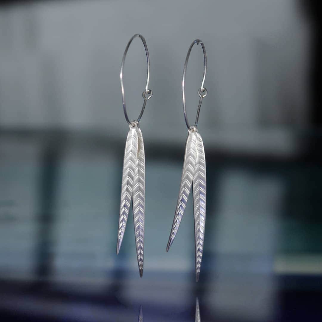 のインスタグラム：「These super fine hoops are light and luminous. Centered by two long silver leaves, they recall the length of palm fronds. Swaying at high noon as the sun strikes down, with bright white highlights they create stark shadows on the tropical ground. Detailed lines are engraved by hand along the bowing silver charm, making these hoops stand out in the crowd. Leave behind everything you knew, and sway with confidence into a wild frontier, the future of hoops.」