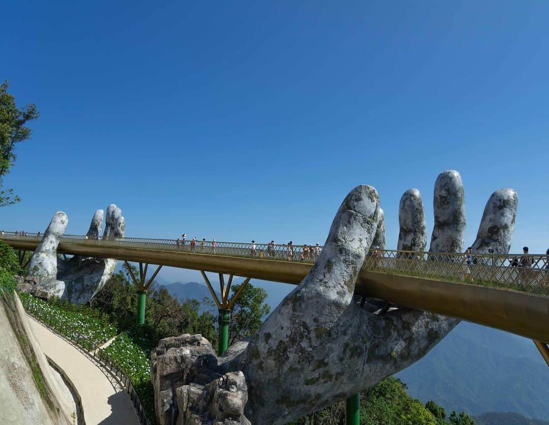 詩歩さんのインスタグラム写真 - (詩歩Instagram)「✈️﻿ ﻿ 橋を支える巨大な手😳⁉﻿ Two huge hands support the bridge!!﻿ ﻿ まるでCGみたいなこの橋は、できたてホヤホヤ！﻿ ﻿ ベトナム中部の街 #ダナン のバーナーヒルズ内に、2018年6月に完成したばかり。﻿ ﻿ SNSで初めてここの写真をみたときは、ビックリしたな〜。。﻿ こんな場所が、身近なベトナムにあるなんて！﻿ ﻿ 長さ150mの橋は「ゴールデンブリッジ」。﻿ ﻿ 森の神さまの手を表しているそうで、ニョキッと差し出された手は、遠くからみてもよし、間を歩いてもよしで、何往復も歩いちゃいました。﻿ ﻿ ダナンは、日本から直行便も出ている話題の都市。﻿ #shiho_vietnam  で、2年前と今回の写真がみれるのでぜひCHECKしてね😉﻿ ﻿ ﻿ ﻿ 📍バーナーヒルズ／ベトナム　ダナン﻿ 📍Ba Na Hills／Vietnam　Da Nang﻿ ﻿﻿﻿ ﻿﻿﻿﻿ ©︎Shiho/詩歩﻿」5月22日 23時09分 - shiho_zekkei