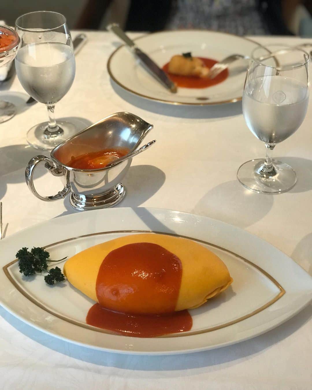 福田淳子さんのインスタグラム写真 - (福田淳子Instagram)「資生堂パーラーで大好きなオムライスを。ここのオムライスはその姿が私にとってオムライス オブ オムライスなんです。アーモンド型なんですがカーブがゆるやかでうっとりする形。そしてトゥるんとした表面のオムレツは幸せの黄色💛そして、このオムライスにあつらえのような上品なお皿。真っ白なテーブルクロスの上でなお一層輝きます。エレガント度がこんなに高いオムライスがあったでしょうか？（いやありません！）箸休めのトッピングがまたもステキなのに乗っかってくるなんて。  いつも平日に来るとお得なモダンランチ（こっちもおススメ。スープ、サラダ、クロケットにメインにカレー又はハヤシライスがちょっとずつ出てくるの。何この夢のセット！）を頼んでしまうのですが、今日はどうしてもこのオムライスが食べたかったので、初志貫徹。 しっかりとしたチキンライスにクリーミーなオムレツにトマトソースは合わせて食べるととてもおいしいです。小さく見えてもけっこうボリューミー。なのに、終わった後にここに来たからには、とプリンア・ラ・モードもしっかり食べました。はー幸せ。  #オムライス #プリンアラモード #資生堂パーラー  #おしゃべりも楽しかった #myfavoritepowerspots」5月23日 23時45分 - junjunfukuda