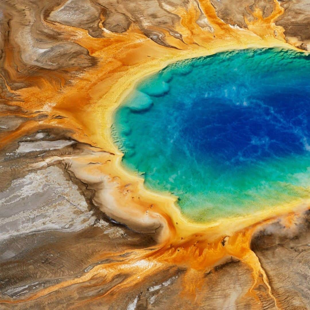 National Geographic Travelさんのインスタグラム写真 - (National Geographic TravelInstagram)「Photo by George Steinmetz @geosteinmetz | Swipe right to see visitors to Yellowstone National Park stroll along a boardwalk near the edge of Grand Prismatic Pool, a natural hot spring. At the center of the pool is 93°C mineral water, which cools as it nears the edges of the pool. The different colors are caused by bacteria that live in different temperatures of water. To view more of our earth from above, follow me, @geosteinmetz.」6月22日 4時19分 - natgeotravel