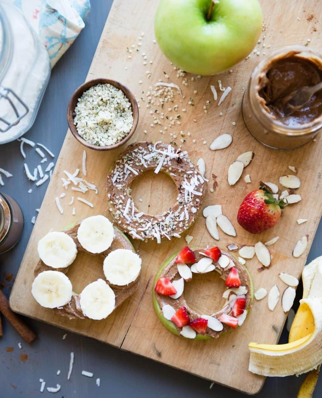 Simple Green Smoothiesさんのインスタグラム写真 - (Simple Green SmoothiesInstagram)「What would you top these darling "donuts" with? 🍏 ﻿ ﻿ APPLE CINNAMON "DONUTS" / serves 1﻿ ﻿ INGREDIENTS﻿ 1 green apple (, cored and cut into 1/4-inch rings)﻿ 1 tablespoon almond butter﻿ 1/4 teaspoon ground cinnamon﻿ 1/4 teaspoon vanilla extract﻿ OPTIONAL: Top with shredded coconut, hemp hearts, sliced strawberries or bananas﻿ ﻿ INSTRUCTIONS﻿ 1. Stir cinnamon and vanilla extract into the almond butter.﻿ 2. Spread a thin layer of the almond butter on one side of each apple ring.﻿ 3. Sprinkle with desired toppings and eat immediately.﻿ ﻿ #plantbased #mealplanning #vegan #vegetarian #healthysnacks #fuelyourpassion #rawkstar #simplegreensmoothies」6月18日 2時30分 - simplegreensmoothies