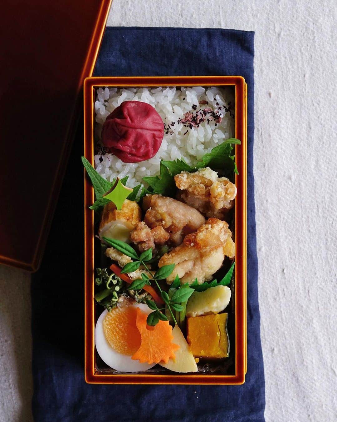 Ryoko Yunokiのインスタグラム：「+ + + Karaage, fried chicken bento/鶏の唐揚げ弁当 . *rice and umeboshi *fried chicken *wild green and veggies salad *chikuwa and cheese *hard-boiled egg *dashi-simmered acorn squash, fish cake and bamboo shoot . ＊ご飯と梅干し ＊鶏の唐揚げ ＊蕨と野菜のお浸し ＊竹輪チーズ ＊ゆで卵 ＊南瓜と笹蒲鉾と筍の出汁煮 . . This fried chicken is marinated in soy sauce, sake and yuzu-flavored paste + + + #bento #お弁当 #丸の内弁当 #f52grams #春慶塗 #飛騨春慶」