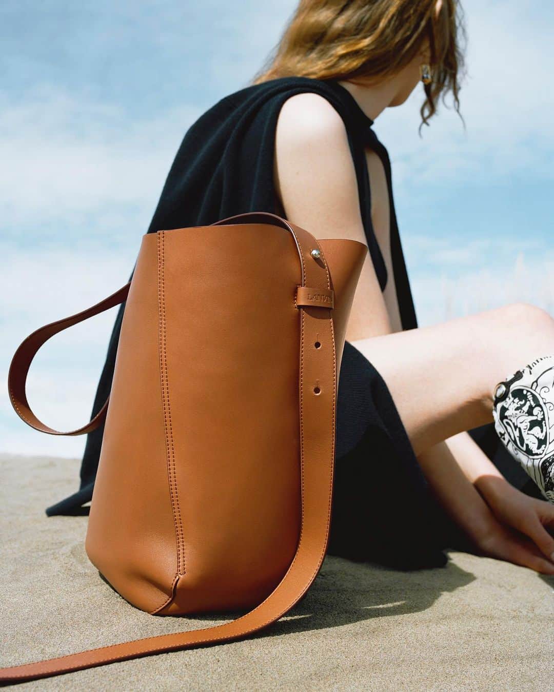 ランバンのインスタグラム：「NEW ON LANVIN.COM — Shaped as a bucket, in a smooth calfskin, the #LanvinHook bag, designed by @brunosialelli, is now available for pre-order. Photography by @quentinsaunier  #LanvinFW19」