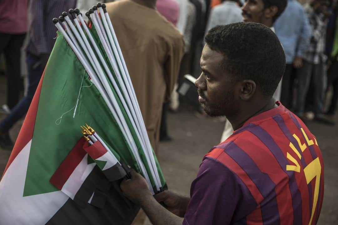 ルモンドさんのインスタグラム写真 - (ルモンドInstagram)「Au cœur de Khartoum, capitale du Soudan, l’aéroport est bordé sur sa partie nord par tout un ensemble de bâtiments militaires. Sa vaste enceinte comprend aussi une résidence présidentielle, et, un peu plus bas, le siège des services de renseignement soudanais. Devant les portes entre le Nil et l’état-major de l’armée de l’air et de celui de la marine, se tient le sit-in, cette cité de la révolution qui a poussé avec ses tentes et ses manifestants. Dans cette ville si grande, si étalée, c’est dans ce tout petit coin que se joue la situation politique du pays. Après le renversement d’Omar Al-Bachir, le 11 avril, le Soudan est le théâtre, dans une tension croissante, de difficultés à trouver une solution à la transition. Une grève générale de deux jours devrait débuter dans ce climat, mardi 28 mai. >> Retrouvez l'actualité du continent Africain sur notre compte : @lemondeafrique - 1 : Au sein du sit-in, dans le centre de la capitale, Khartoum, le 25 mai. 2 : Les centaines de manifestants prennent l’iftar chaque jour sur place. 3 : Installés devant les bâtiments du ministère de l’aviation, de la marine et de la défense, les manifestants prient au coucher du soleil. - Photos : Laurent Van der Stockt (@laurentvanderstockt) #PourLeMonde - #Soudan #SudanUprising」5月28日 18時10分 - lemondefr