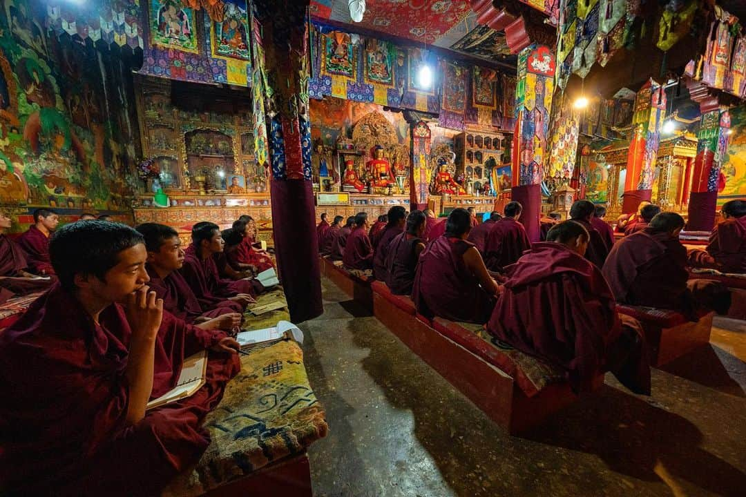 Michael Yamashitaさんのインスタグラム写真 - (Michael YamashitaInstagram)「Sponsored by @sonysingapore | Inside the prayer hall at Tashi Lhunpo Monastery, my Sony’s Eye Autofocus has no trouble in the low light with it’s 5 axis in-body image stabilization, and locks onto the eyes of the young monk with his hand up to his chin, even at this extreme wide angle.  EXIF: 1/15sec, f/4, ISO5000 #SonyAlpha #A9 + #SonyGMaster #SEL1635GM #SonyEyeAF @sonysingapore」5月29日 4時51分 - yamashitaphoto