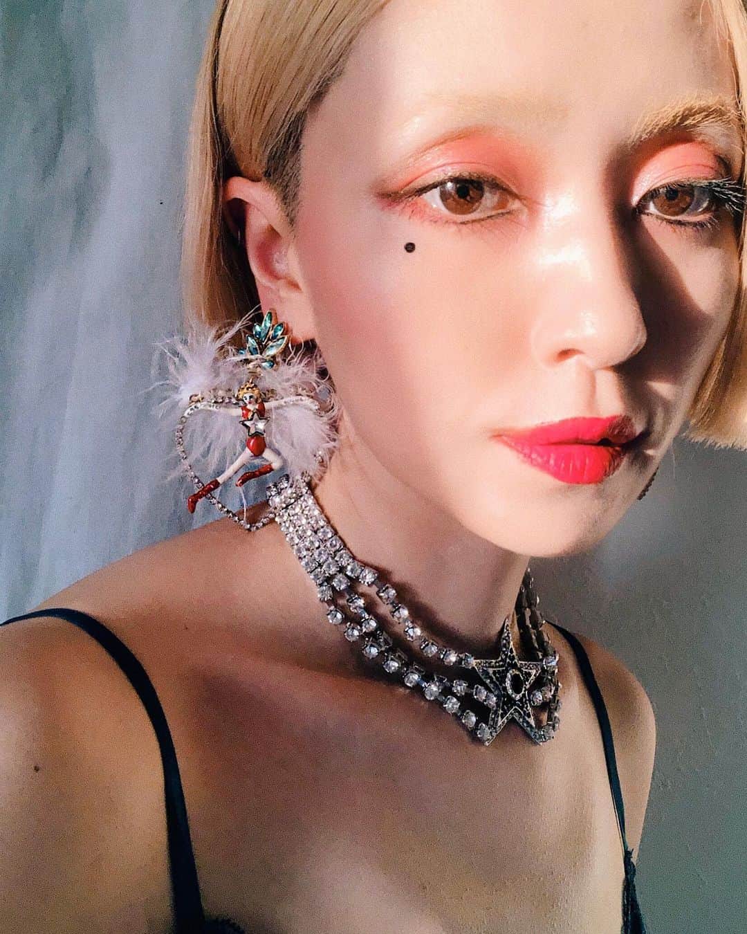 PELIのインスタグラム：「ベルベットマットのルブタンのリップカラー💄💄💄 ピンク系のメイクの時には優しめなコーラルレッドのDramadoucが馴染むな！ リップボディのデザインは古代遺品の秘薬が入った小瓶がインスパイアだそう✨🏺✨ネックレスにもなるらしい！これをプラプラしたらアルトワ伯になれる💜こういうロマン好きだなー😍😍 6/5発売だそうです🔮 @louboutinbeauty #LouboutinBeauty #RougeVelvetMatte #MyRougeMyWay レビュー風のピアスと星ネックレスは#klosetdesign の👯‍♀️👯‍♀️👯‍♀️ #アルトワ伯 のリップ」