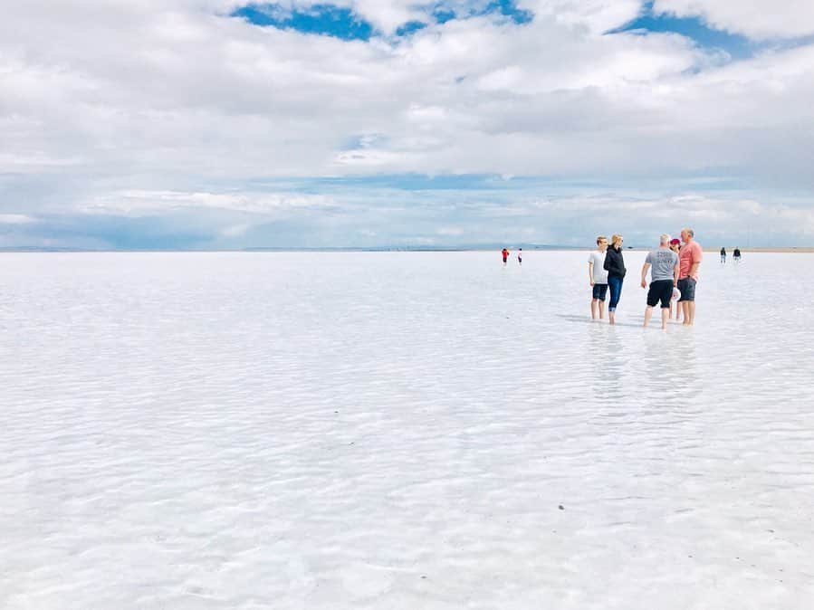 香山ひとみさんのインスタグラム写真 - (香山ひとみInstagram)「#アメリカ生活国内旅行編 Bonneville Salt Flats . 先日のメモリアルデー休暇を利用して、 イエローストーン＆塩湖旅行に行ってきました✈️✨ . まずは、ユタ州にある塩湖、 【ボンネビル・ソルトフラッツ】へ。 せっかくアメリカにいるし、一度は南米ボリビアのウユニ塩湖へ行きたい...😭と願っていましたが、ボリビアへのアクセスの悪さや、治安や高山病の恐れから、子連れでは難しいだろうと断念。すると友人から、ユタ州にも塩湖があるとの情報を😆✨ ソルトレイクシティ空港から車で1時間半で行けるお手軽塩湖です🙆‍♀️✨ . 当日、着くまでは、かなりの暴風雨で、見ることを半ば諦めていましたが、着いて20分ほど待つと、 雨が止み、車を降りると、、、 そこには、 一面に広がる揺らめく世界✨✨✨ 風がふき水面がなびくたびに、 雪のような白銀だったり 深みのあるブルーだったり、様々な表情を見せながらキラキラと輝いていました。 . 風が強く、絵に描いたような水面に反射した景色は見られなかったものの、 足跡もなければ遮るものも何もなく、自分たちがいる以外何もないような、、 同じ塩湖に人はいるのにどこか別世界の人たちのような。 なんとも言えない不思議な感覚になりました。 . これから夏になると、 水は蒸発し干上がり、表面が塩で覆われた真っ白な平原が続くそう。 鏡張りの景色には、 ・干上がる前の春〜夏前 ・前日に雨が降る ・風がない ・晴れの日 などの条件が必要なので、必ず見たい方は、何日か取っておいた方がいいかもしれません🙆‍♀️💕 . ビーチサンダルとタオル、 裾を捲り上げられるパンツ必須😹 私はデニムだったので捲り上げると、ぱっつんぱつんぱっつんのふくらはぎが、うっ血気味になりながら頑張っていました😂（どーでもいい情報😂） . . #ボンネビルソルトフラッツ #塩湖 #bonnevillesaltflats #saltlake #イエローストーン旅行 #yellowstonetrip . #海外生活 #アメリカ生活 #子連れ旅行 #子連れ海外旅行 #ユタ州」5月30日 15時07分 - hitomi.k24