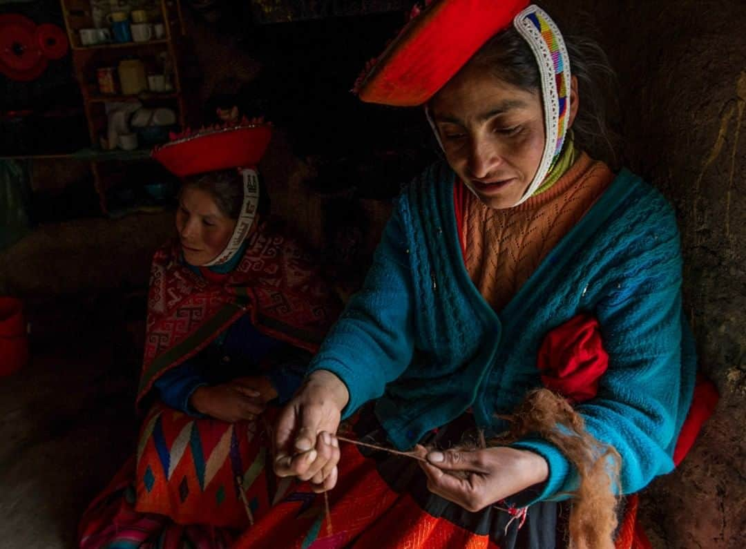 National Geographic Travelさんのインスタグラム写真 - (National Geographic TravelInstagram)「Photo by @bethjwald | Quechua women, wearing the dress and hat that are typical of the Patacancha region in the Sacred Valley of Peru, spin yarn inside a traditional thatched adobe home in a village above Ollantaytambo. The women are part of a collective of women weavers which helps them create their traditional textiles and market them for fair prices so that their fine craft can help them sustain their families and their cultural traditions. #culturalsurvival #tradition #peru #sacredvalley  For more photos of traditonal  cultures from around the world, follow me at @bethjwald」5月31日 7時16分 - natgeotravel