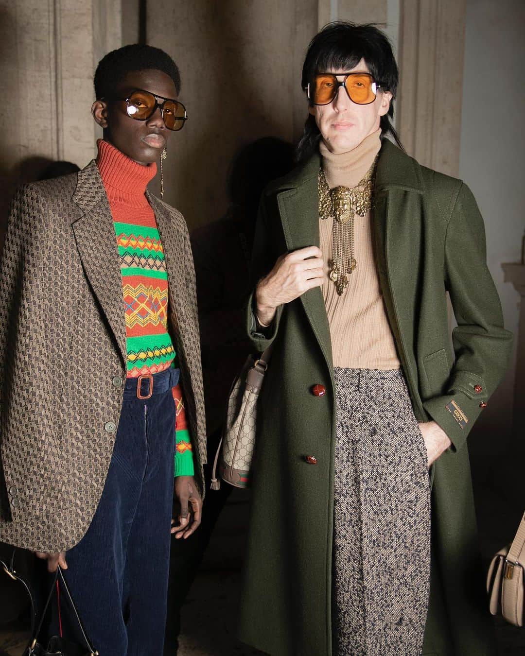 のインスタグラム：「Wearing a long coat, trousers and a necklace featuring the face of Hercules, singer-songwriter and musician @bradfordcox, lead singer of band @deerhuntermusic together with another men’s style with a jacquard knit, tailored jacket and flared trousers by @alessandro_michele for the #GucciCruise20 fashion show. Both looks feature #GucciEyewear with yellow lenses. #AlessandroMichele @museiincomuneroma #MuseiCapitolini See a video of the show through link in bio.」