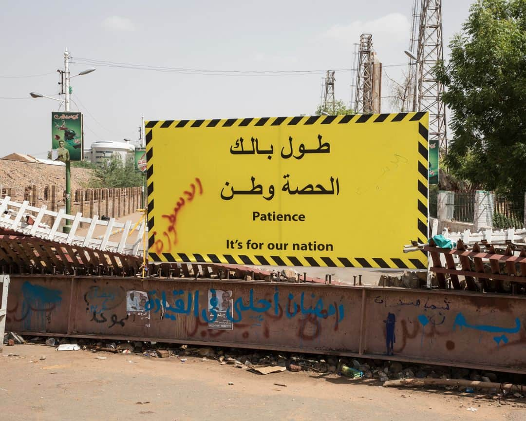 ルモンドさんのインスタグラム写真 - (ルモンドInstagram)「Khartoum 31 mai. Les ruraux qui envahissent les rues du centre sont là pour signifier une possible divergence du programme. Un test. Collectivement, ils ressemblent un peu au visage de la contre-révolution : on les a convoyés pour leur faire dire à quel point ils croient plus au pouvoir des militaires, à la prédominance du respect de l’islam qu’à toute autre considération présidant à l’organisation de la société soudanaise. Et qu’ils se contrefichent de la série de choses qui se discutent dans les rues de Khartoum nuit et jour, à moins de quinze minutes de marche.  Alors que géographiquement, tout se déroule dans un mouchoir de poche, on ne saurait être plus éloigné. Alors qu’au sit-in, festival de l’élan démocratique au Soudan, le débat et la fête continuent devant le quartier général de l’armée, un autre pays semble avoir envahi la rue pour un sit-in bis, mais express aux abords de l’avenue Al Qasr, l’avenue du palais, qui débouche effectivement à la présidence, ou plus exactement à l’entrée des deux présidences conjointes qui trônent le long du Nil : l’ancienne, toute blanche datant de la période coloniale, et l’autre, toute de marbre et de pierre sculptés, offerte par la Chine. >> L’actualité du continent africain est aussi sur notre compte @lemondeafrique<< - 1 et 2 : Après les deux jours de grève organisée par les dirigeants du mouvement civil de contestation, ceux ci continuent à occuper le sit-in aux abords du quartier général de l'armée. 31 mai.  3 et 4: En fin de journée, une manifestation en faveur du conseil des militaires a réuni plusieurs centaines de personnes amenées en bus au centre-ville.  Des slogans en faveur de la charia en vigueur étaient chantés et des portraits de Hemeti et de Abdel Fattah al-Burhane, les chefs du conseil militaire, étaient brandis.  Photo : @laurentvanderstockt #PourLeMonde — #Sudan #Uprising」6月1日 14時12分 - lemondefr