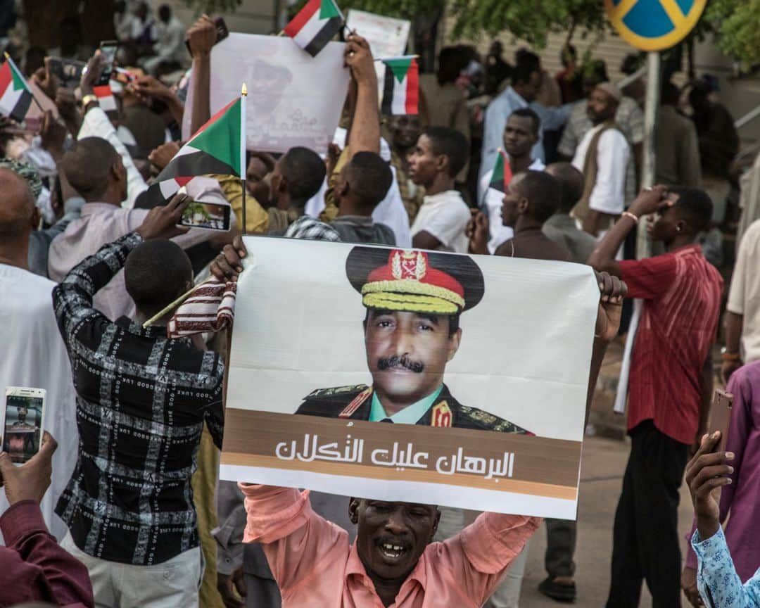 ルモンドさんのインスタグラム写真 - (ルモンドInstagram)「Khartoum 31 mai. Les ruraux qui envahissent les rues du centre sont là pour signifier une possible divergence du programme. Un test. Collectivement, ils ressemblent un peu au visage de la contre-révolution : on les a convoyés pour leur faire dire à quel point ils croient plus au pouvoir des militaires, à la prédominance du respect de l’islam qu’à toute autre considération présidant à l’organisation de la société soudanaise. Et qu’ils se contrefichent de la série de choses qui se discutent dans les rues de Khartoum nuit et jour, à moins de quinze minutes de marche.  Alors que géographiquement, tout se déroule dans un mouchoir de poche, on ne saurait être plus éloigné. Alors qu’au sit-in, festival de l’élan démocratique au Soudan, le débat et la fête continuent devant le quartier général de l’armée, un autre pays semble avoir envahi la rue pour un sit-in bis, mais express aux abords de l’avenue Al Qasr, l’avenue du palais, qui débouche effectivement à la présidence, ou plus exactement à l’entrée des deux présidences conjointes qui trônent le long du Nil : l’ancienne, toute blanche datant de la période coloniale, et l’autre, toute de marbre et de pierre sculptés, offerte par la Chine. >> L’actualité du continent africain est aussi sur notre compte @lemondeafrique<< - 1 et 2 : Après les deux jours de grève organisée par les dirigeants du mouvement civil de contestation, ceux ci continuent à occuper le sit-in aux abords du quartier général de l'armée. 31 mai.  3 et 4: En fin de journée, une manifestation en faveur du conseil des militaires a réuni plusieurs centaines de personnes amenées en bus au centre-ville.  Des slogans en faveur de la charia en vigueur étaient chantés et des portraits de Hemeti et de Abdel Fattah al-Burhane, les chefs du conseil militaire, étaient brandis.  Photo : @laurentvanderstockt #PourLeMonde — #Sudan #Uprising」6月1日 14時12分 - lemondefr