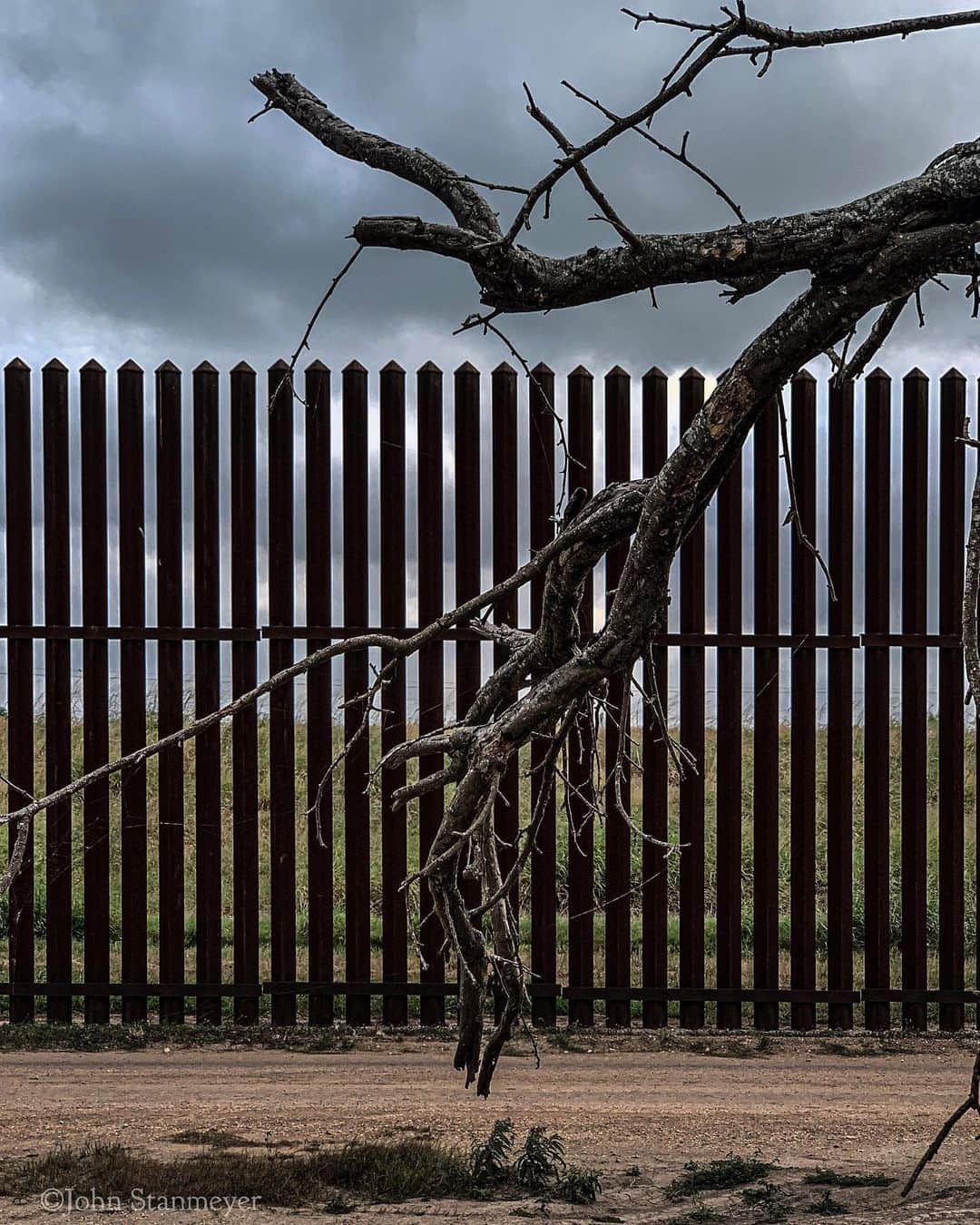 ジョン・スタンメイヤーさんのインスタグラム写真 - (ジョン・スタンメイヤーInstagram)「Things we grow, decay, leave behind, the strangest species we are. Scars of erosion, metal, plastic, the landscape of our human devise, all along the line that divides. Poems of our heavy footprint along the US/Mexico border. - @natgeo @insidenatgeo #usmexicoborder #borderfence #texas #pigs #deadtree #plasticflowers #memorials #waste #decay」6月1日 8時01分 - johnstanmeyer