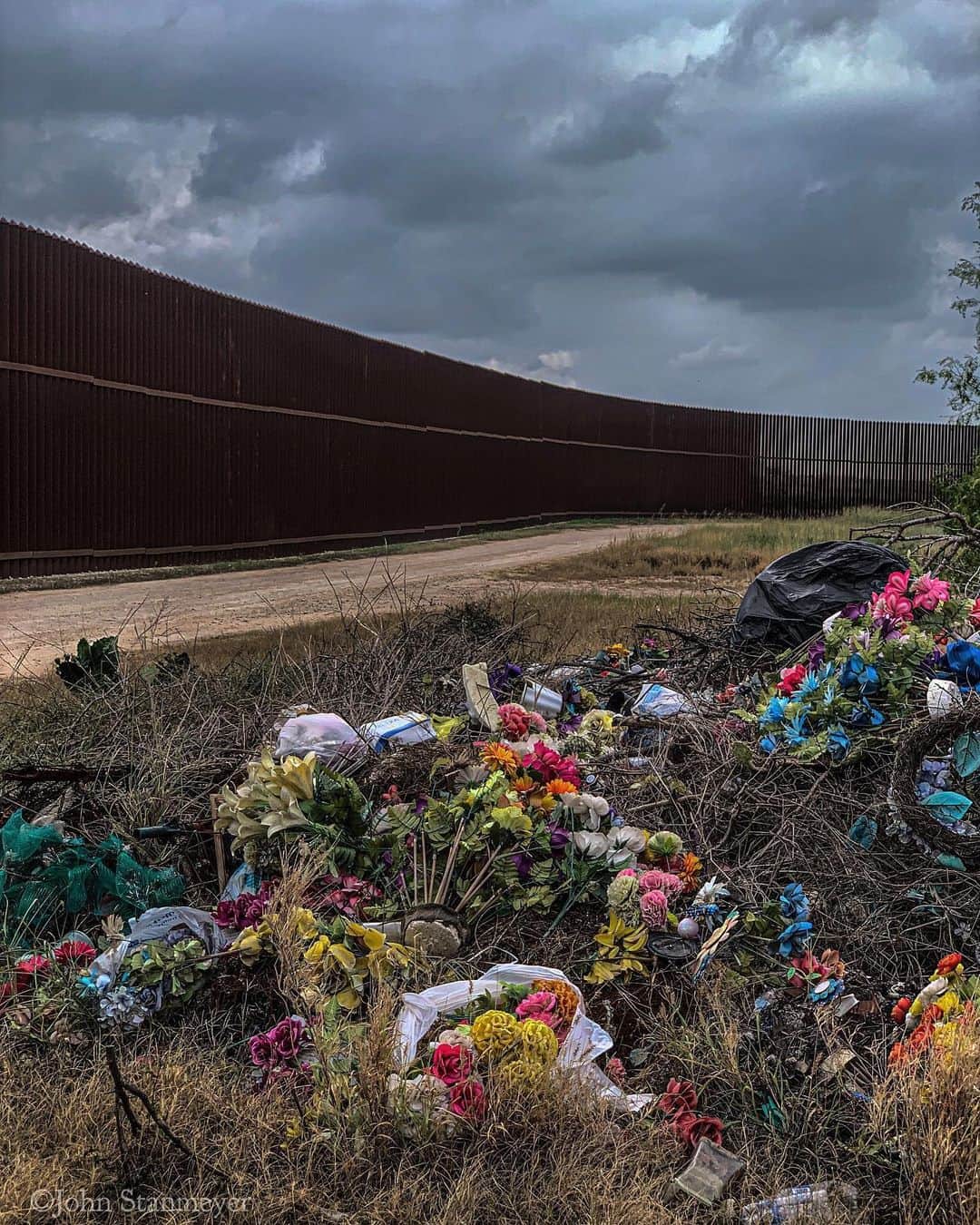 ジョン・スタンメイヤーさんのインスタグラム写真 - (ジョン・スタンメイヤーInstagram)「Things we grow, decay, leave behind, the strangest species we are. Scars of erosion, metal, plastic, the landscape of our human devise, all along the line that divides. Poems of our heavy footprint along the US/Mexico border. - @natgeo @insidenatgeo #usmexicoborder #borderfence #texas #pigs #deadtree #plasticflowers #memorials #waste #decay」6月1日 8時01分 - johnstanmeyer