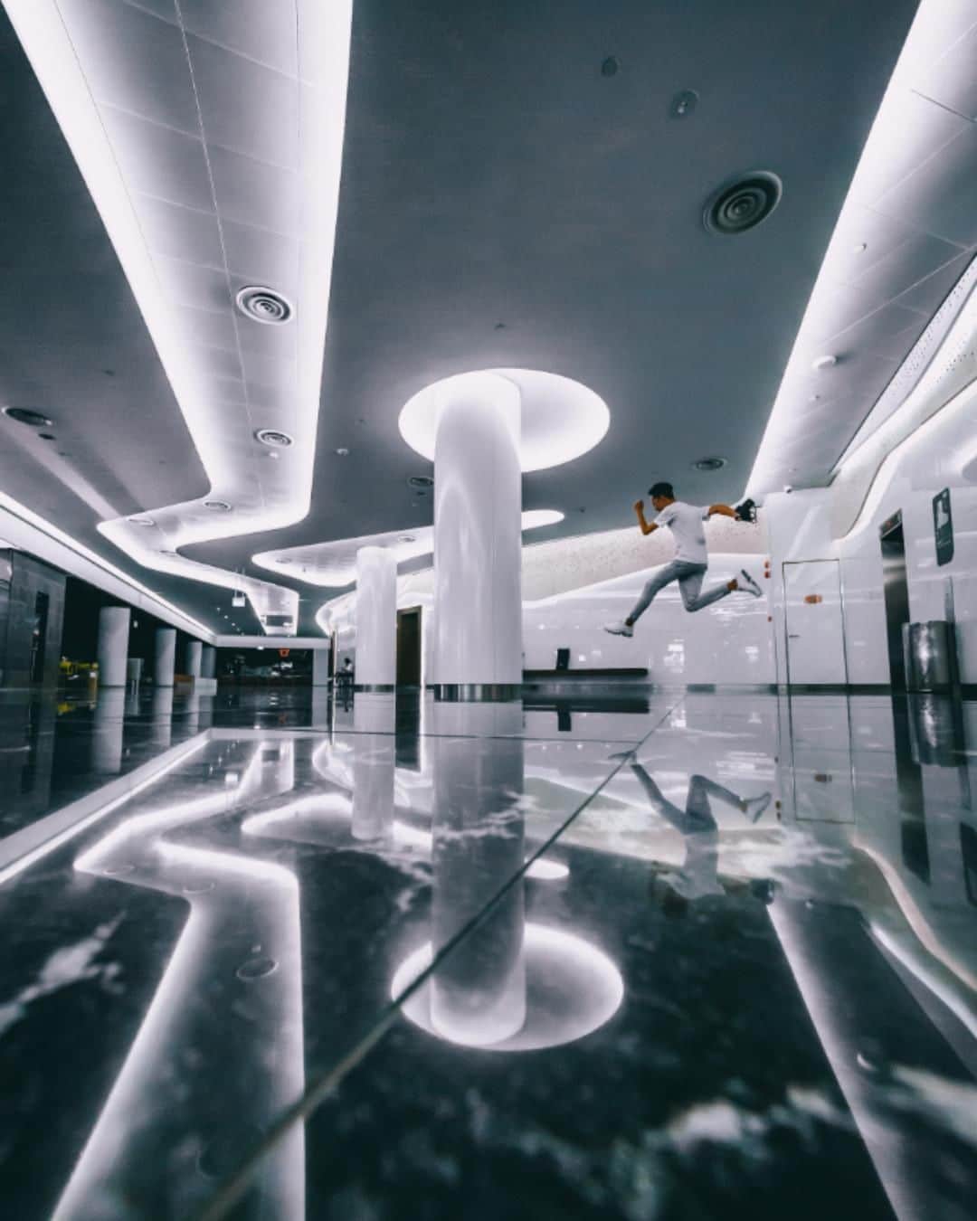 Canon Asiaのインスタグラム：「"Although there weren't many people on a Sunday afternoon, there were still some curious onlookers observing us on the sides while we were trying to capture this shot." Never mind the curious stares. With the glistening white lights hitting the glossy floor ✨, and a well-timed jump of the subject captured in frame 🏃‍♂️, @unfilialed created an intriguing reflection shot! •  Got a reflection shot of your own? Share them with us by tagging us at #canonasia. We would love to see your photographs! • 📷 Image by @unfilialed using the Canon EOS 5D Mark III | f/4.5 | 1/160s | ISO 4000 | 12mm  Want your photos to be featured too? Tag them with #canonasia or submit them on My Canon Story, link in bio!  #canonasia #photography #canonphotography #singapore #architecture #architecturephotography」