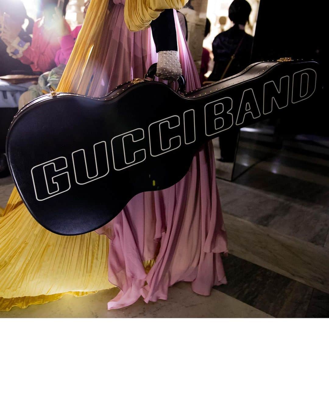 のインスタグラム：「‘Gucci Band’ is written on the guitar case carried with a long pleated silk chiffon gown designed with a trail and black velvet details by @alessandro_michele. @museiincomuneroma #AlessandroMichele #MuseiCapitolini #GucciCruise20 See a video of the collection through link in bio.」