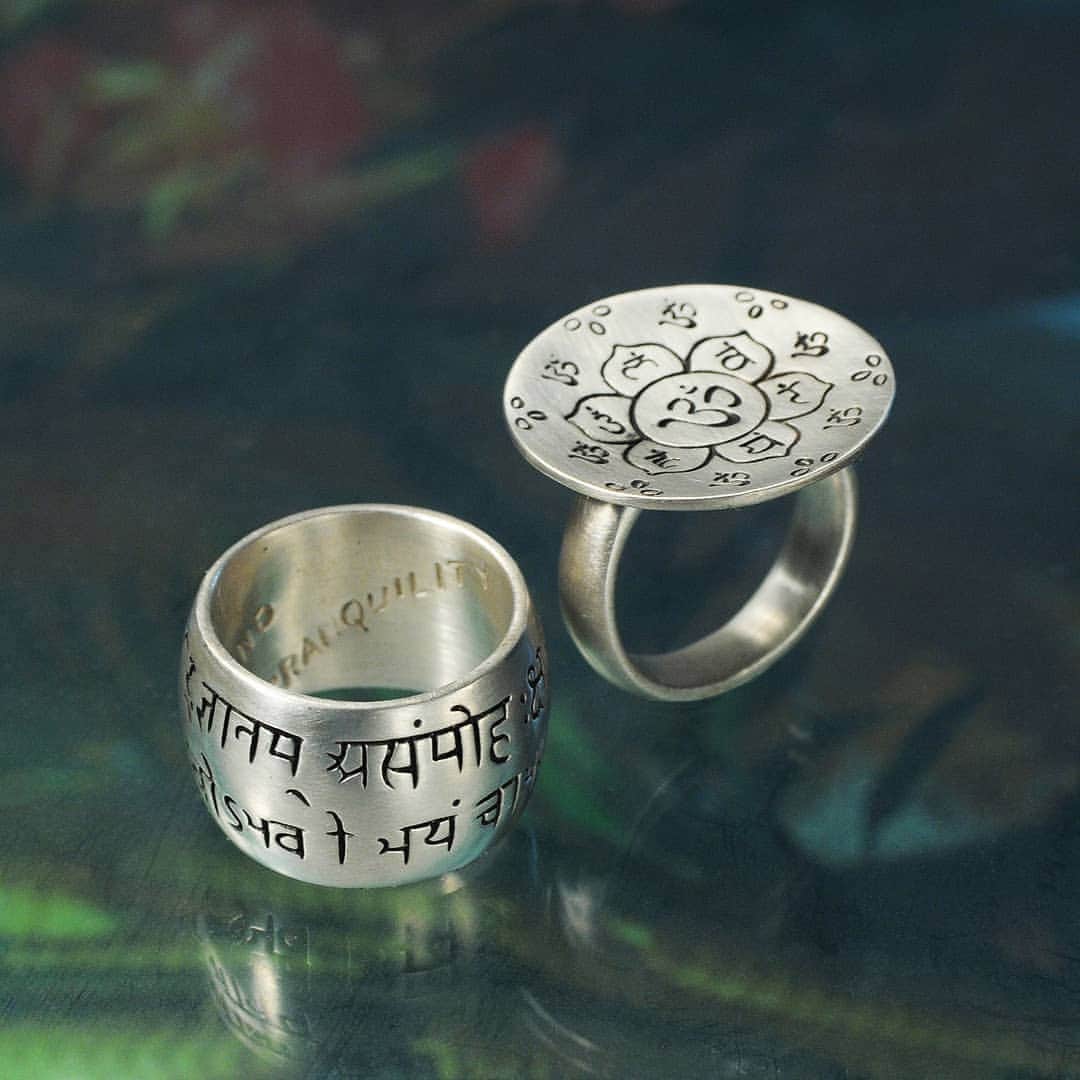 のインスタグラム：「Through the dialogue between a prince and his guide, in the Hindu epic The Bhagvad Gita, four spiritual paths are paved. These sterling silver rings are engraved with the sacred language of Sanskrit and its symbolism. One is wrapped in a verse from the Gita that speaks of patience, truth, self-restraint, and tranquility... while the other opens up divine abstraction. On its big disc, this ring amends the philosophies of the other, with a lotus flower and “Om”, the sound of the universe. These large silver rings channel the dialogue of one of our world’s most ancient literate cultures.」