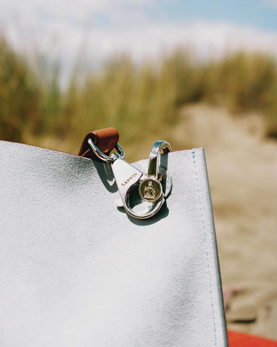 ランバンのインスタグラム：「THE HOOK — The historical drawing of The Woman and Child by Paul Iribe, a key signature of the house, seen here finely engraved on the metal hardware of the #LanvinHook bag. Photography by @quentinsaunier  #LanvinFW19」
