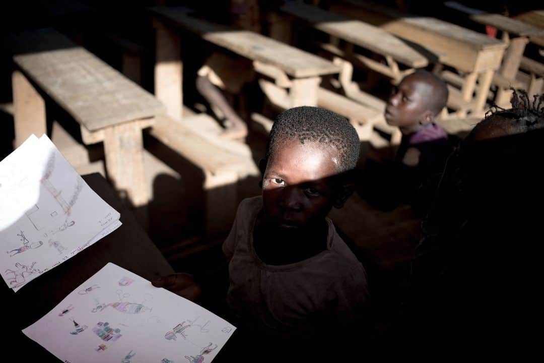 のインスタグラム：「AFP Photo 📷 @florentvergnes_jri - A child hands his drawings to the psychologist at the Lazare camp for internally displaced people (IDP) in Kaga Bandoro. . In the northern part of the country devastated by the crisis, the International Red Cross has set up a workshop to detect and treat Post Traumatic Stress Disorder through drawing.」