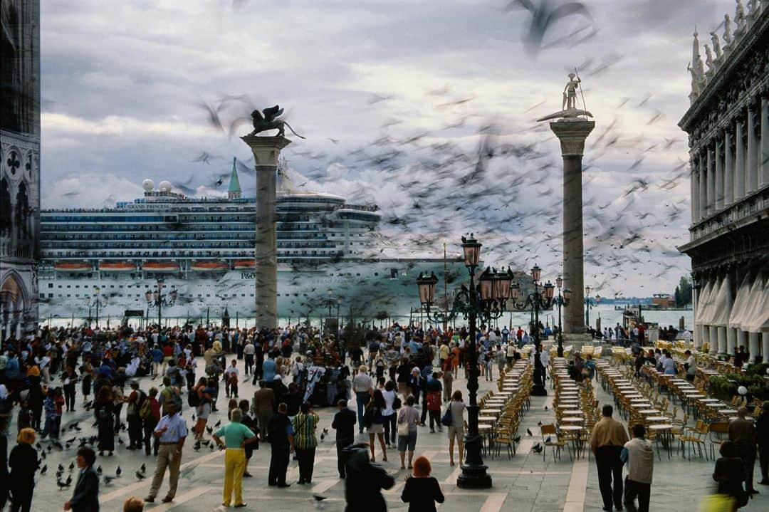 Michael Yamashitaさんのインスタグラム写真 - (Michael YamashitaInstagram)「The Grand Princess enters the city of Venice, dwarfing the 15th century buildings edging San Marco Square. A blast of her horn sends pigeons scattering into the sky, completing my picture. In yesterday’s news, a similar sized behemoth turned dangerous when the out-of-control cruise ship wiped out a dock and a tourist boat in Venice, causing injuries and panic in this beautiful but over-touristed and sinking city. Though tourist dollars are welcomed by many here, others now say the risk to this iconic city’s citizens and its fragile ecosystem churned up by these giants is too high a price to pay.  #Venice #cruiseship #PiazzaSanMarco #StMarksSquare」6月5日 4時35分 - yamashitaphoto