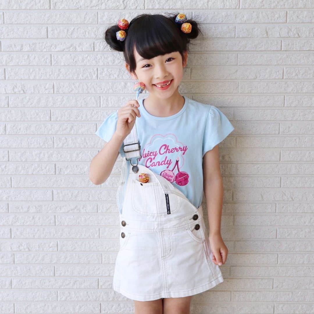 Akiのインスタグラム：「6/5 ・ お義母さんに買っていただいた 白サロペスカート まだ着れた☺️ #サイズ100 ・ ・ @gu_for_all_ の新作 チュッパチャップス×グラフィックT🍭 ・ 若者はチュッパチャップスを 頭に刺すそうで せっかくなのでやってみた☺️🍭 ・ ・ 歯抜けで悪魔フェイスの娘も Tシャツの水色のおかげで 若干爽やかに見える😈♡← ・ それにしても相変わらず 口閉じて笑えない🤷‍♀️👄 ・ ・ ・ ・ #gu_for_all#GUstyle#gupr#gukids#グラフィックT#chupachups」