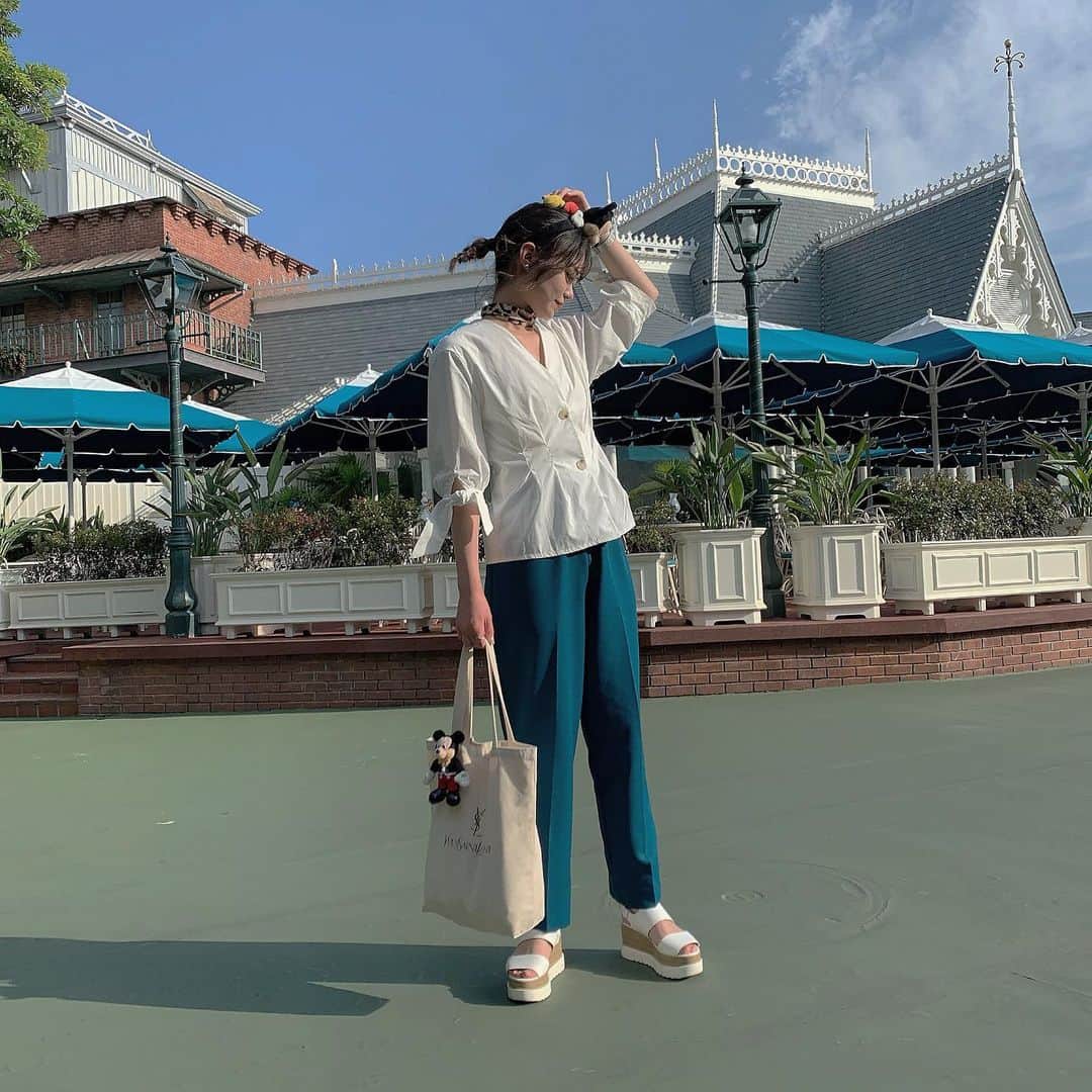 前田亜美のインスタグラム：「. . おすすめの #ディズニーコーデ を載せます¨̮. . とりあえずディズニーはたくさん歩くので…. ぺったんこorスニーカー。慣れた靴が定番です！. . そして、どこで撮っても写真映えするので…. 顔の周りは出来るだけ華やかに明るめな服の色を選ぶと🙆🏻. . カチューシャのバランスをみて髪型も変えたりします！. . (※髪型は別で投稿します). . tops・shoes @dholic_official . pants  古着. scarf  韓国で購入  青はディズニーで映える✌︎. . #ディズニー #Disney #私服 #ディズニーコーデ #シミラールック #古着ディズニー #ミッキーマウス  #ami私服  #コーディネート  #シミラールック #リンクコーデ #シミラールックディズニー」