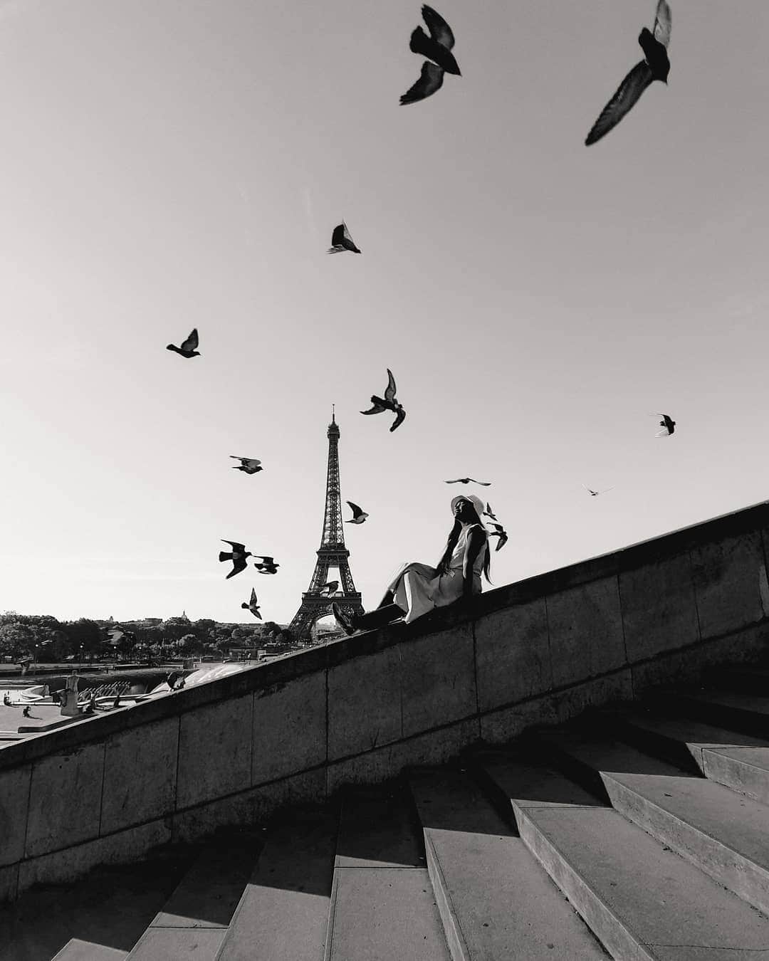 のインスタグラム：「An everlasting // this is quite an obligatory photo when you come to Paris for the first time. The thing is, @satyawinnie is lucky enough that these birds were flying above her. She's also pretty lucky that i held my phone and click the shutter as soon as the birds passing us by. I guess both of us were pretty lucky because i came here like lots of times but it's my first time to capture the birds like this. It was not bad at all.  And i put this in black and white to make it more everlasting, like my friend said when i asked him for an advice. Also, i was thinking about a legendary pict of Elliot Erwitt in Eiffel tower as well. So, hope you enjoy the black and white version. . . Taken with @samsung_id #withgalaxyS10 #withgalaxy」