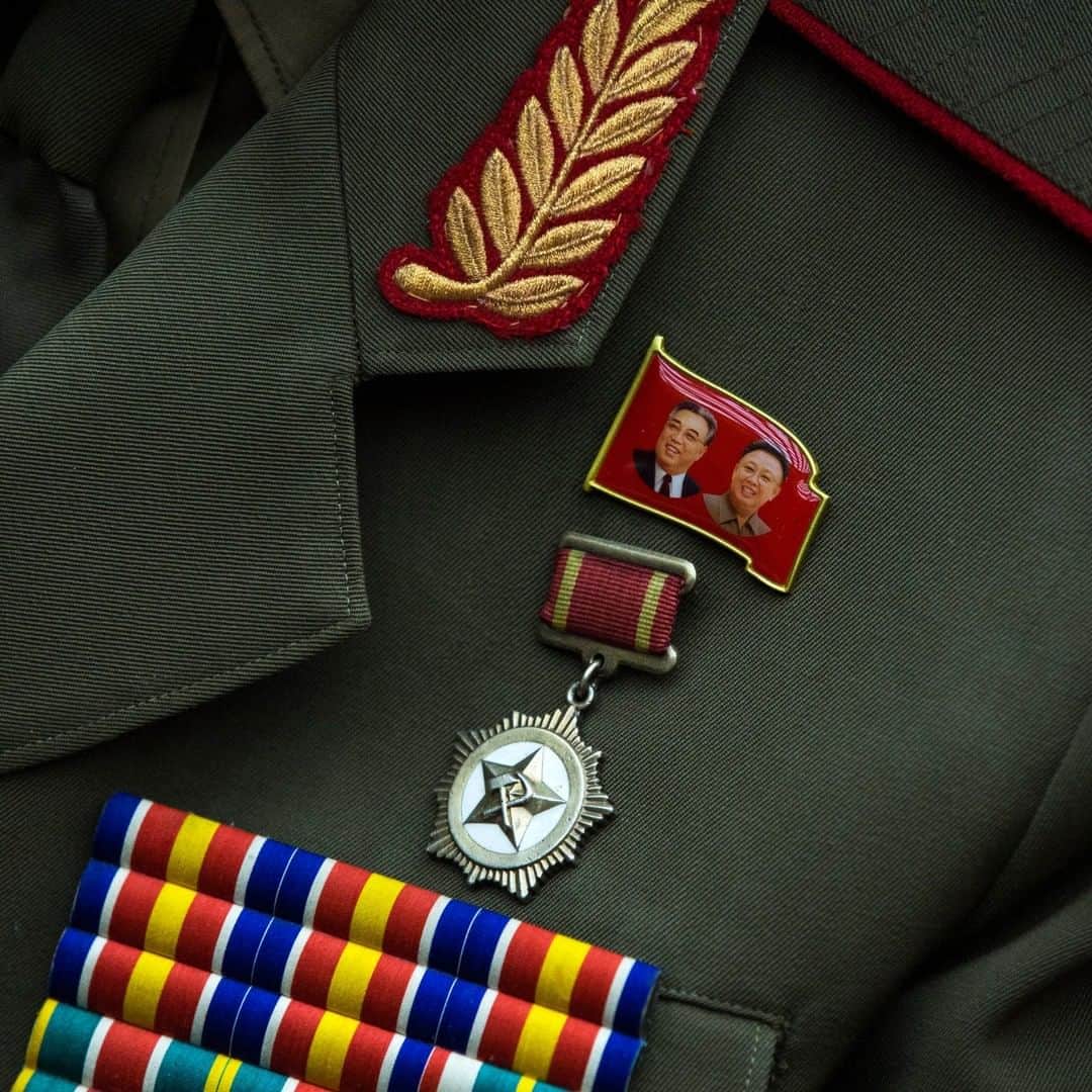 のインスタグラム：「Photo by David Guttenfelder @dguttenfelder | A pin with the faces of late North Korean leaders Kim Il Sung (left) and Kim Jong Il is attached next to a medal and military bars on the uniform of a female North Korean soldier. Please follow me, @dguttenfelder, for an inside look at North Korea, where I have been traveling and photographing for the past 19 years.」