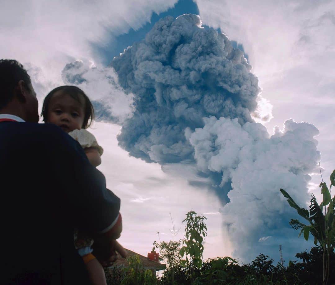 ABC Newsさんのインスタグラム写真 - (ABC NewsInstagram)「A man carries a child as he watches Indonesia's Mount Sinabung shooting a column of ash thousands of feet into the air as it erupted on Sunday. No injuries have been reported, but authorities are urging residents who live nearby to use masks when the ash rains down. Sinabung, which has sporadically erupted since 2010 after being dormant for 400 years, is among more than 120 active volcanoes in Indonesia. (AP Photo)」6月10日 9時40分 - abcnews