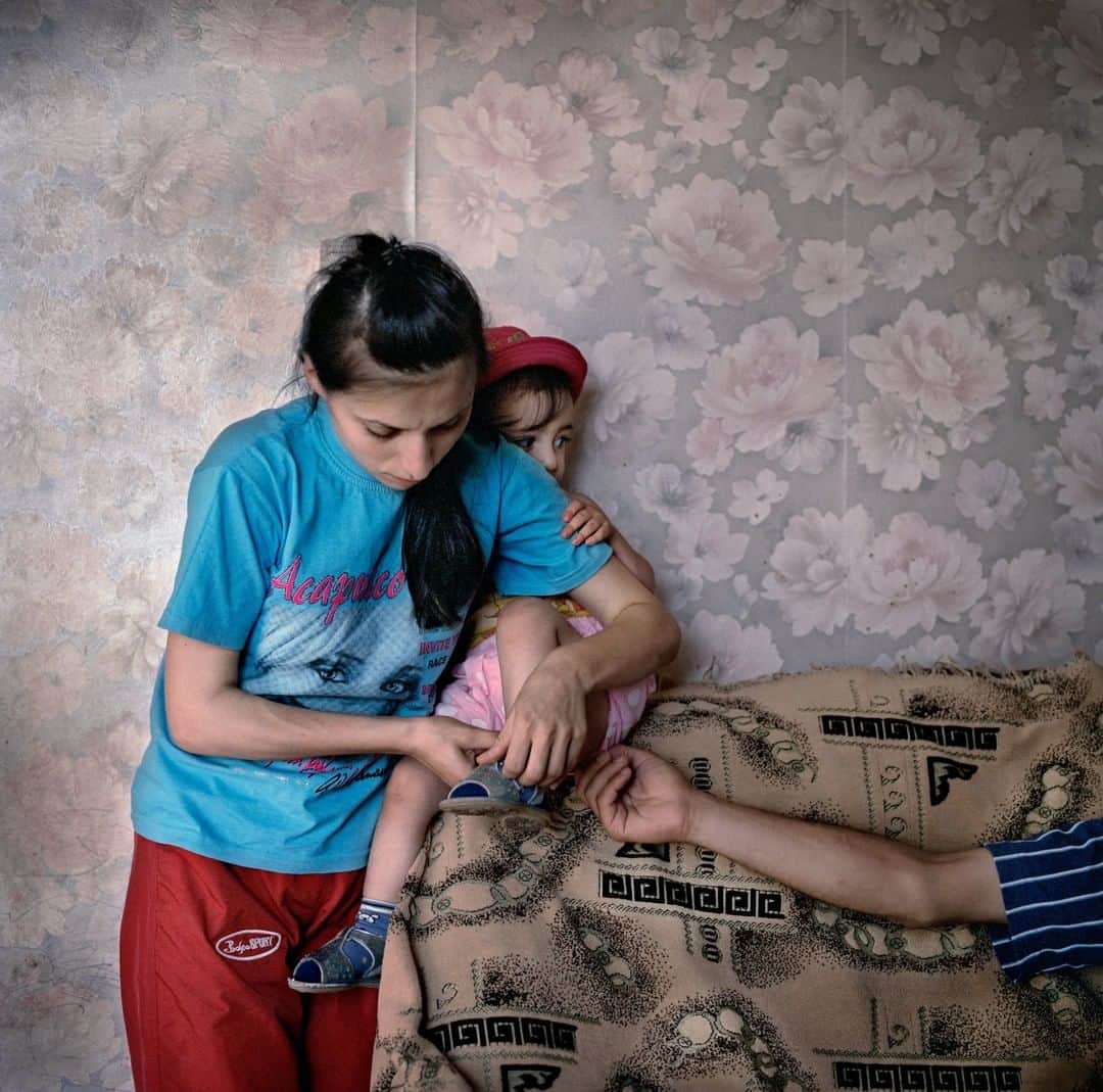 のインスタグラム：「Photo by Anastasia Taylor-Lind @anastasiatl | Marianna Avanesyan puts on her two-year-old daughter Mane’s shoes at home in Askeran, Nagorno Karabakh. Marianna and her husband, Sevak Gurgenyan, got married in a 2008 mass wedding and have so far received approximately €2,800 ($4,000) from the private businessmen who organized and funded the wedding, and expect a further €2,100 ($3,000) shortly for the birth of their second child, Nare.」