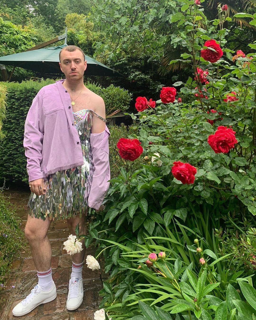 Vogue Runwayさんのインスタグラム写真 - (Vogue RunwayInstagram)「@SamSmith took the humdrum gardening uniform to fantastic new heights. Posing in an Instagram share showing Smith alongside a red rose bush in a metallic silver fringe cocktail dress and a pale pink button down, Smith brought old school disco glamour to the garden. Tap the link in our bio for more details on his perfect versatile summer outfit, one that’s as much at home in a lush garden as it is on the dance floor. #regram @samsmith」6月12日 2時57分 - voguerunway