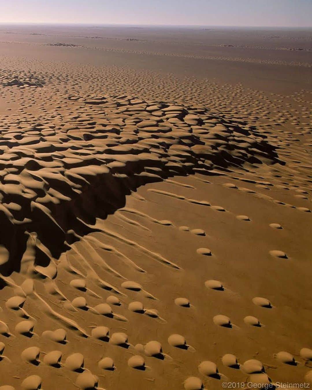 thephotosocietyさんのインスタグラム写真 - (thephotosocietyInstagram)「Photo by George Steinmetz @geosteinmetz | Thamud, Yemen | On my second crossing of Arabia’s Empty Quarter, I found some strange looking dunes in old satellite data that a friend of mine at NASA shared with me. It was pretty low rez imagery, so I didn’t really know what to expect when I took off with my paraglider at sunrise. 90% of life is showing up! This monster barchan dune appeared to be spawning. #DesertAirBook #EmptyQuarterBook  #paramotor  To explore more of our earth from above, follow @geosteinmetz」6月12日 6時34分 - thephotosociety