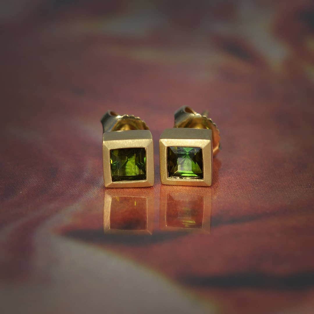 のインスタグラム：「The electric energy of green tourmalines recharge all parts of the body. Wholesome yet entrancing, their earthy hue brings us to a place of natural wonder. These handcrafted 18k gold earrings activate such stunning gems with the stability and exacting geometry of right angles. The mitered corners of their setting match the sophisticated structure of these princess cut tourmalines, making for a commanding stud earring that struts from day to night. All stones are conflict free.」