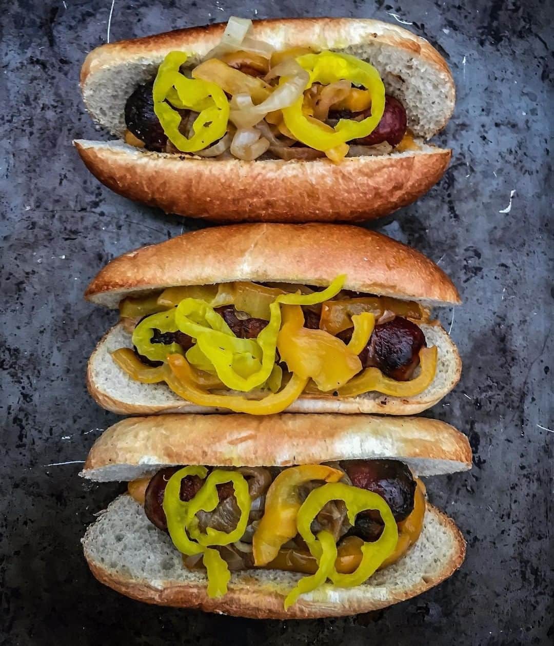 ジョンソンヴィルのインスタグラム：「@j_dubble_q sure knows how to kick off the summer in style with some #Johnsonville #OriginalBrats ☀️☀️ What are you grilling this weekend?  #SunsOutBunsOut * * "I served up those bacon wrapped @johnsonville brats with some sautéed onions and peppers and topped them with banana peppers! Have a great day everyone! • #traegerbbq #traeger #traegernation #traegergrills #brats #bacon #baconwrapped #sandwich #sandwhiches #woodfired #idsmokethat #onionsandpeppers #sandwichporn #grilling #nationalbbqmonth #grillseason #instagood #eeeeeats #f52grams"」
