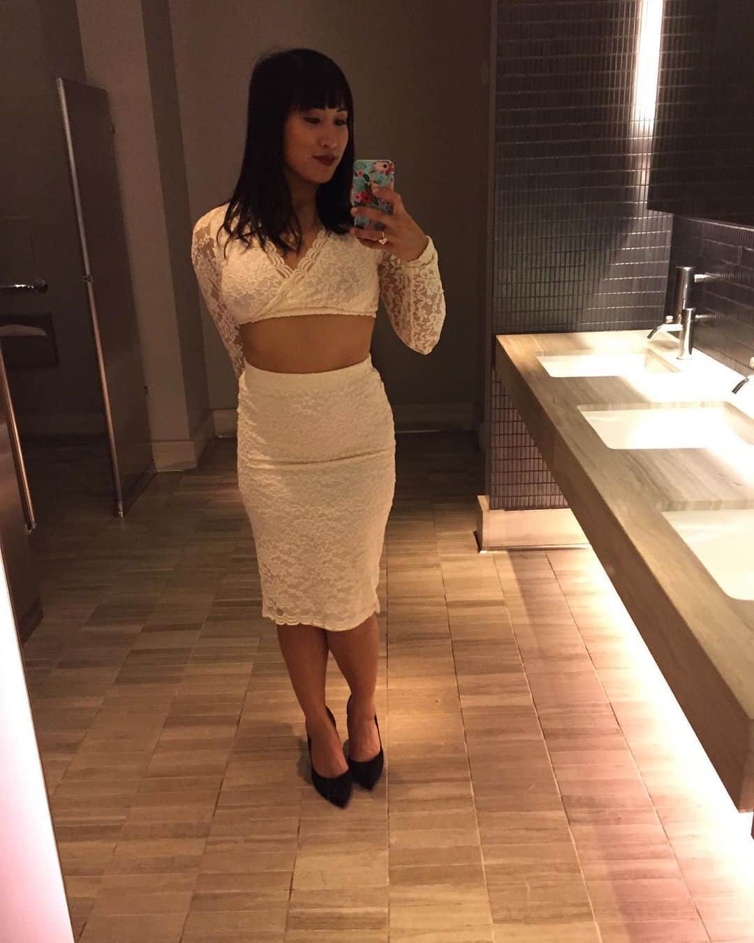 のインスタグラム：「I love this look from years ago I’ve been feeling womanly as of late. Body changes are the constant turning of seasons. And sometimes I feel like a Goddess. [photo description: Mia is taking a full body mirror selfie in a marble bathroom. Mia is wearing an ivory lace long sleeve cropped top with a matching ivory lace pencil skirt and black pointed toe pumps.]」