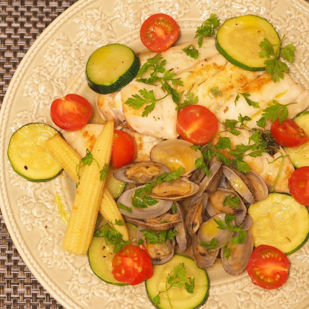 のインスタグラム：「珍しくレシピ紹介👩‍🍳😋🍽 鶏胸肉に飽きた方必見❣️ 【アクアパッツァ🐟🐚】 ・・材料・・ 白身魚(切り身でOK) あさり ヤングコーン ズッキーニ トマト …その他野菜なんでも！ にんにく チャービル又はパセリ オリーブオイル ハーブソルト 白ワイン 塩 水 ・・作り方・・ 1. 白身魚に軽く塩を振って30分ほど冷蔵庫で寝かせる。 2. 魚をオリーブオイルで両面焼き色がつくまで焼く。 3. 水200ccぐらい？とあさりと刻んだにんにく、野菜を入れて蓋をして煮込む。 4. あさりが開いたら、白ワインを入れてアルコールが飛んだら火を止める。 5. 仕上げにオリーブオイルとハーブソルトをかけてチャービルを盛り付けて完成！ . . 仕上げのオリーブオイルは香りの高いものを使うとフルーティで美味しいよ✌️ 簡単で美味しいからぜひ作ってみてね！夏野菜をたっぷり入れて季節の味を楽しんでね🥰🥒🍅 減量じゃない人は、残りの煮汁をぜひパスタやリゾットに🍝🤤 #アクアパッツァ #魚 #高タンパク低脂肪 #レシピ #ヘルシー #ヘルシーレシピ #減量 #ダイエット #ボディメイク #美味しいもの #自炊 #食べて痩せる #フィットネス #健康美 #フィットネスモデル #パーソナルトレーナー #栄養士」