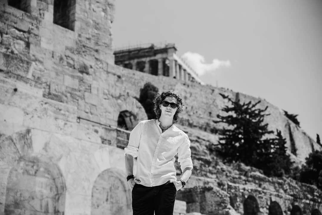 パヴェル・ドローストのインスタグラム：「Ci sarà una rosa e sarà maggio Vorrei che ti guardassi con i miei occhi Vorrei che ti ascoltassi con i miei sogni Sai la mia vita è soltanto un insieme di sogni E tu sei l'unica parte reale che voglio nei giorni, ehi  E quando il mondo ti schiaccia provaci anche tu Tira fuori il bimbo che hai dentro, non nasconderlo più E ti ho portato due fiori, uno sono io e l'altro sei tu E vorrei essere anch'io bello come sei bella tu...💭🎶🍃 . . . Photo by @marie.aranie #ultimo #lapoesiadelcuore #poesiasenzaveli #athens #greece #acropolis #music  #musica #pensamientos #summer #weekend #lavitaebella」