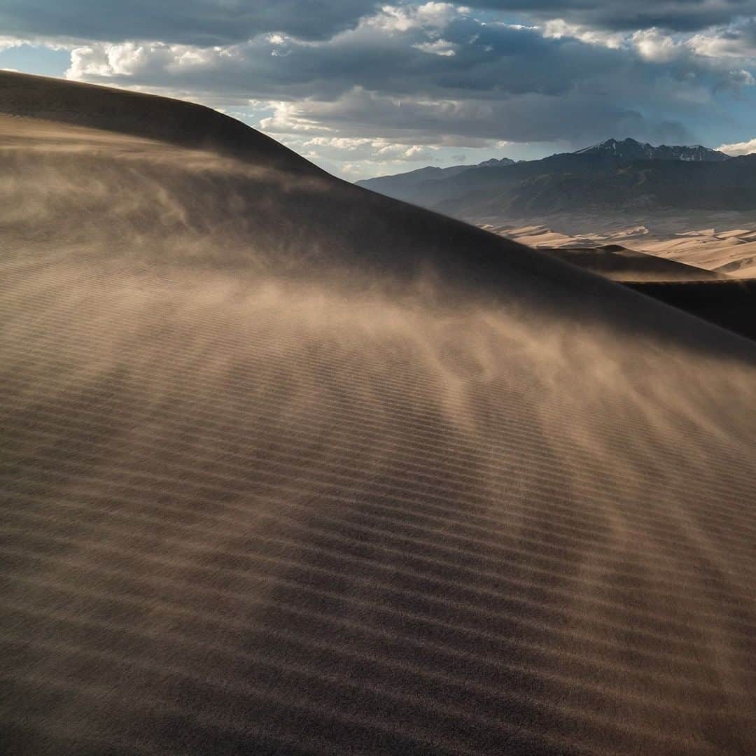National Geographic Travelさんのインスタグラム写真 - (National Geographic TravelInstagram)「Photo by @stephen_matera | The wind blows sand across Great Sand Dunes National Park at sunset in Colorado. The area receives only 11 inches of precipitation each year and was measured to be the quietest of the U.S. National Parks in the contiguous 48 states. Sand temperatures can reach a blistering 140 degrees Fahrenheit during hot summer days and dunes are up to 750 feet high. Follow me, @stephen_matera, to see a video of the sand blowing and for more images like this from Colorado and around the world. #desert #colorado」7月14日 19時00分 - natgeotravel