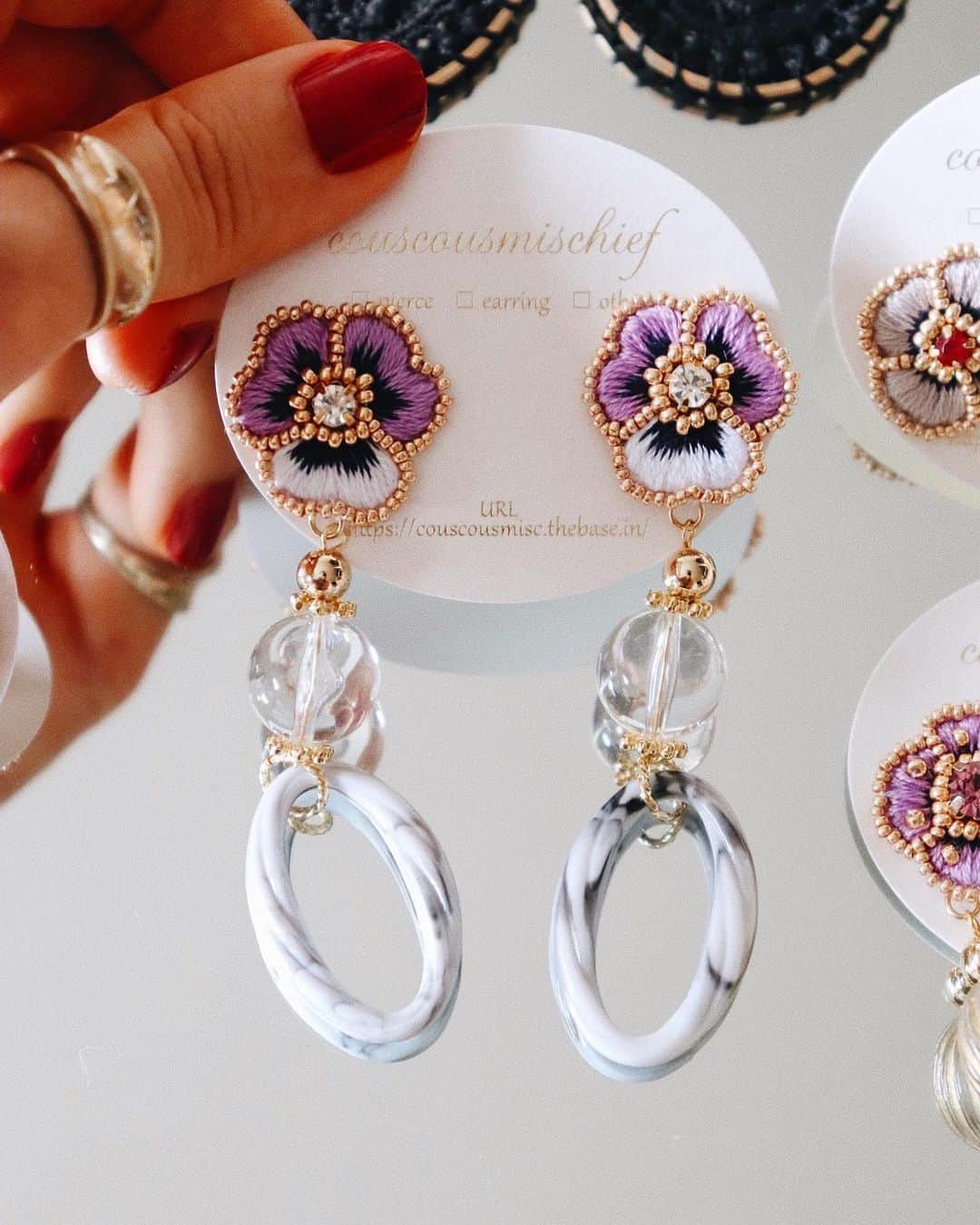 handmade shopのインスタグラム：「パンジーとクリアパーツの組み合わせ🌼﻿ ﻿ ロングタイプなので耳元でゆらゆらと﻿ 揺れてくれます😊💓﻿ ﻿ HMJに持っていきます✨﻿ ﻿ HMJまで1週間をきりました！﻿ わたしは長崎に住んでいるので﻿ 前乗りで東京にいきます﻿✨﻿ ﻿ 準備もそろそろ終わりそうで一安心🌷﻿ ﻿ ﻿ クスクスミスチーフの作品は﻿ 色の組み合わせにこだわり﻿ 女性ならではの上品さや繊細さを意識した﻿ アクセサリー作りを心がけています🌿﻿ ﻿ 毎日ちくちくと針仕事をして﻿ できあがったお花たちです🌼﻿ ﻿ お花を手に取った方に﻿ クスクスミスチーフの世界観を﻿ 楽しめるようにと想いを込めて💓﻿ ﻿ HMJまであと6日😊﻿ ﻿ ﻿﻿﻿﻿ 🌱7/20,21 HMJ ビッグサイト ブースno.B-193」